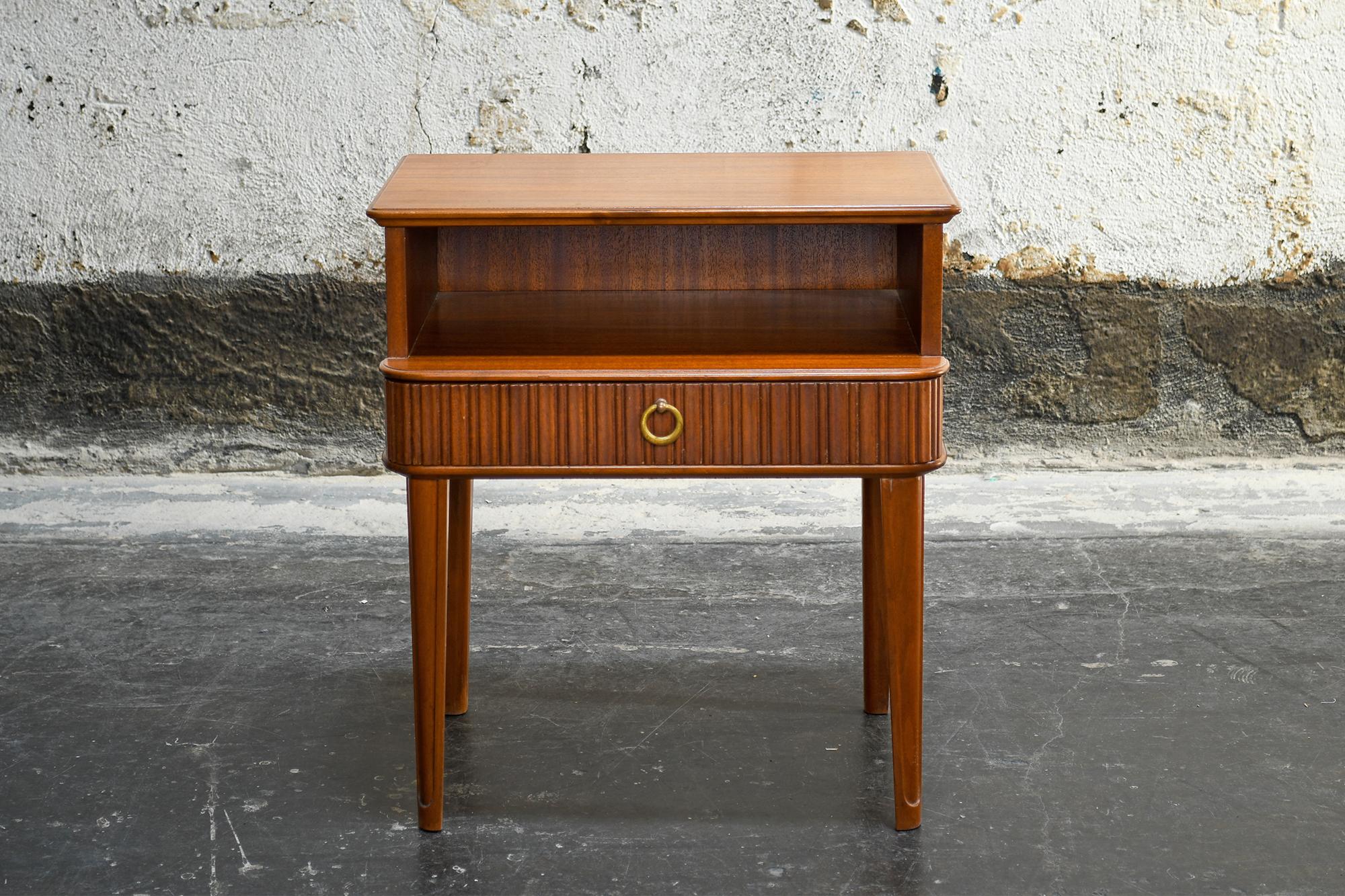 Exceptional pair of ribbon mahogany night stands or end tables with fluted drawers and solid brass ring pulls. These pieces also feature a finished back which is hard to find on pieces style/age.