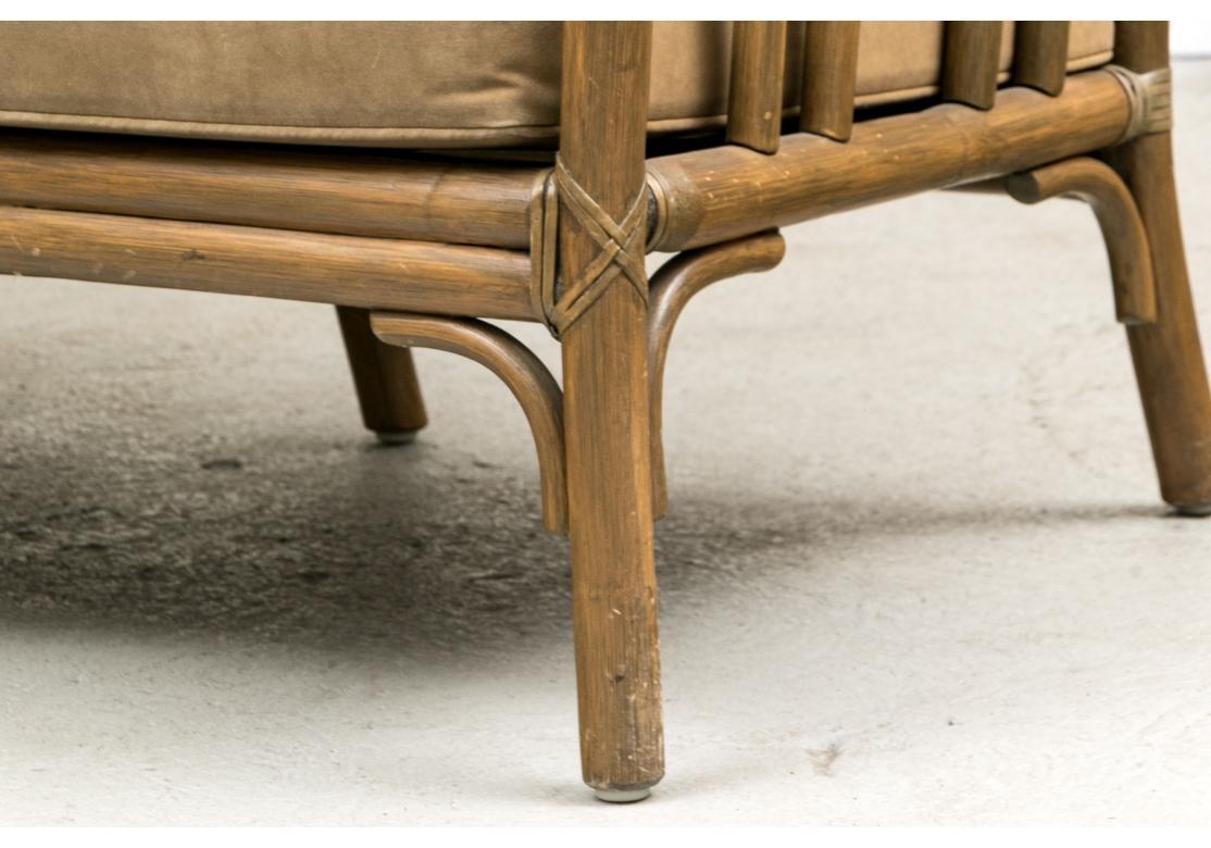 Very well made and solid feeling Rattan Sofas from iconic furniture makers McGuire. With leather straps and leather bonded seat and seat back cushions on canvas strapping. 

Dimensions: 74” wide by 31” deep by 28.25” high. Seat height 16.75”.