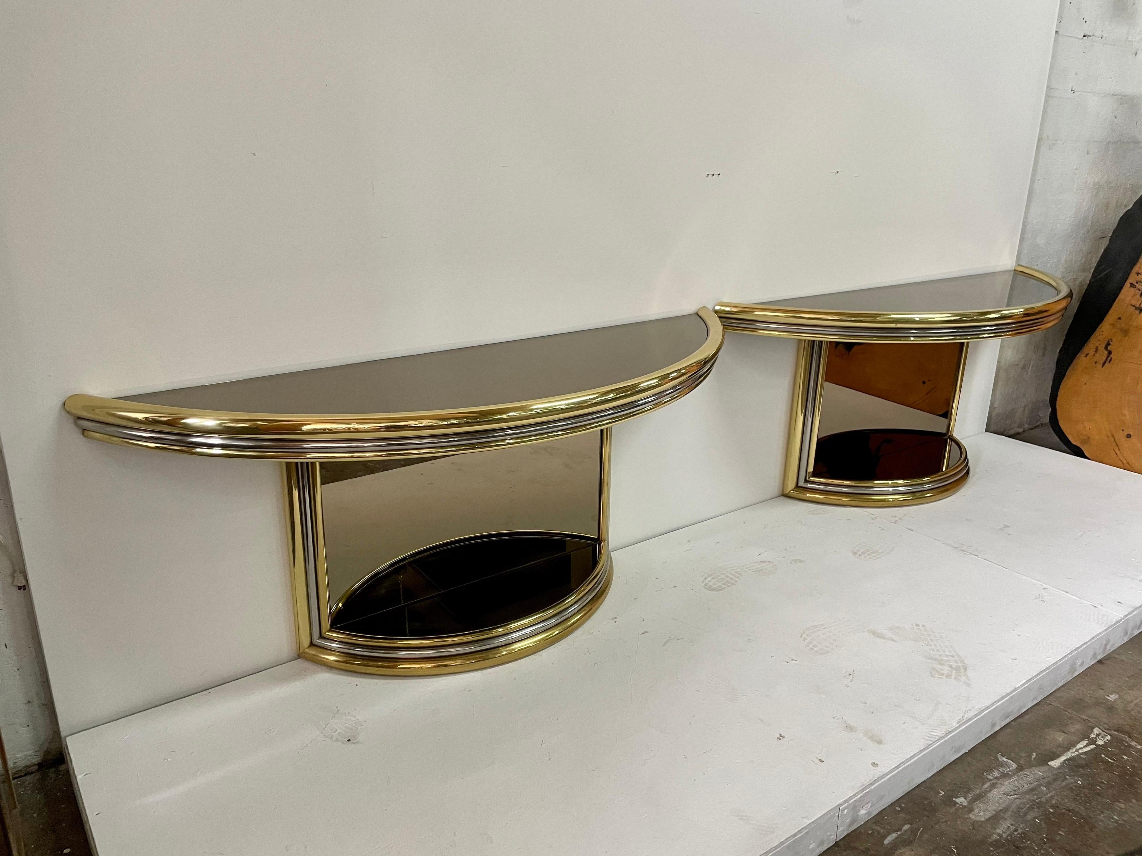 Very large scale, these heavy and well constructed vintage consoles with smoked mirror top and forward facing panels. Tubular design in chrome and brass with some patina small rust spots (see detailed images. This does not affect the overall beauty