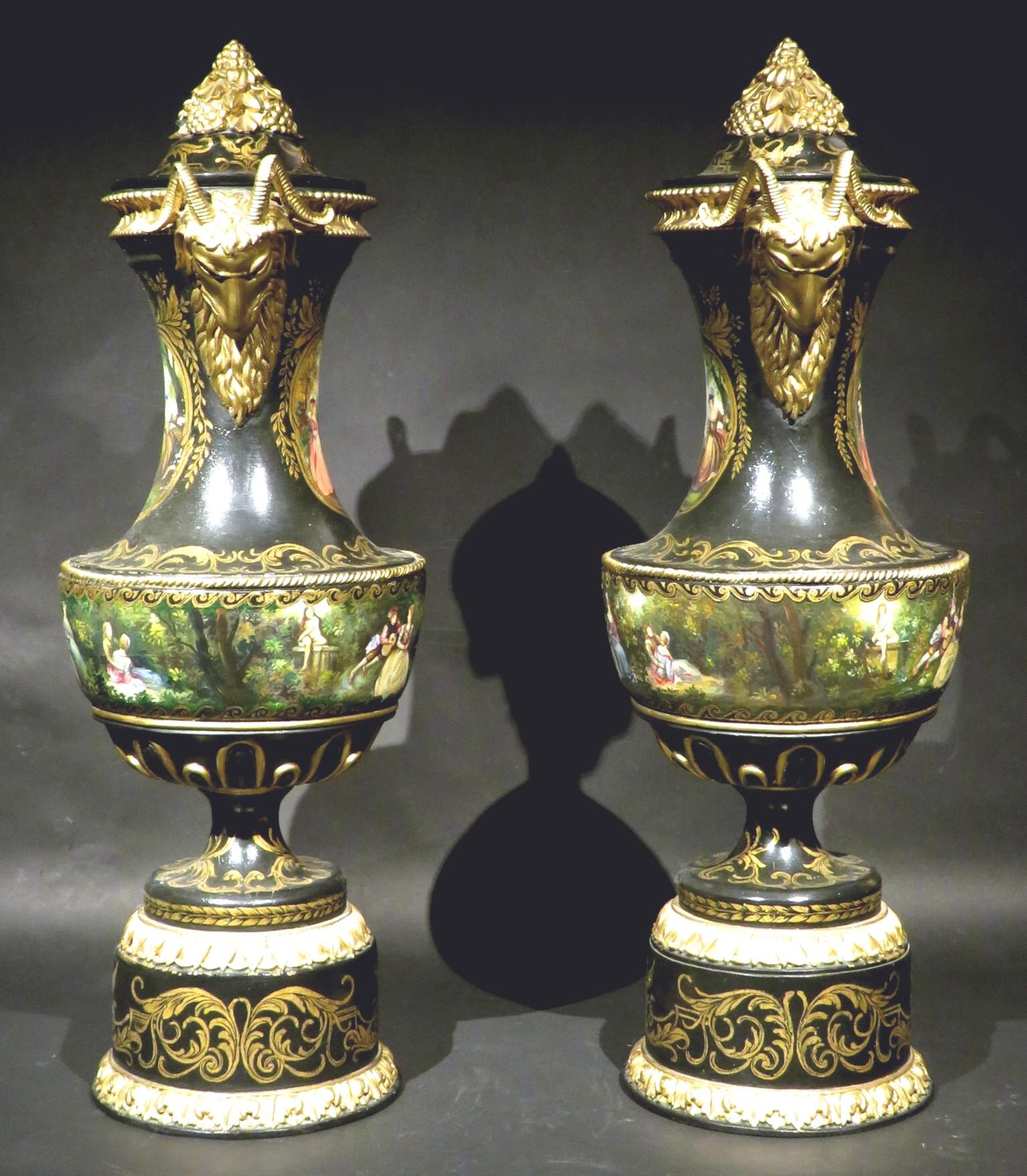 A most impressive & highly decorative pair of 19th century ebonized wooden urns, both fitted with detachable lids with gilded composition mounts, the bodies decorated overall with hand painted gilt motifs and romantic themed murals, the necks
