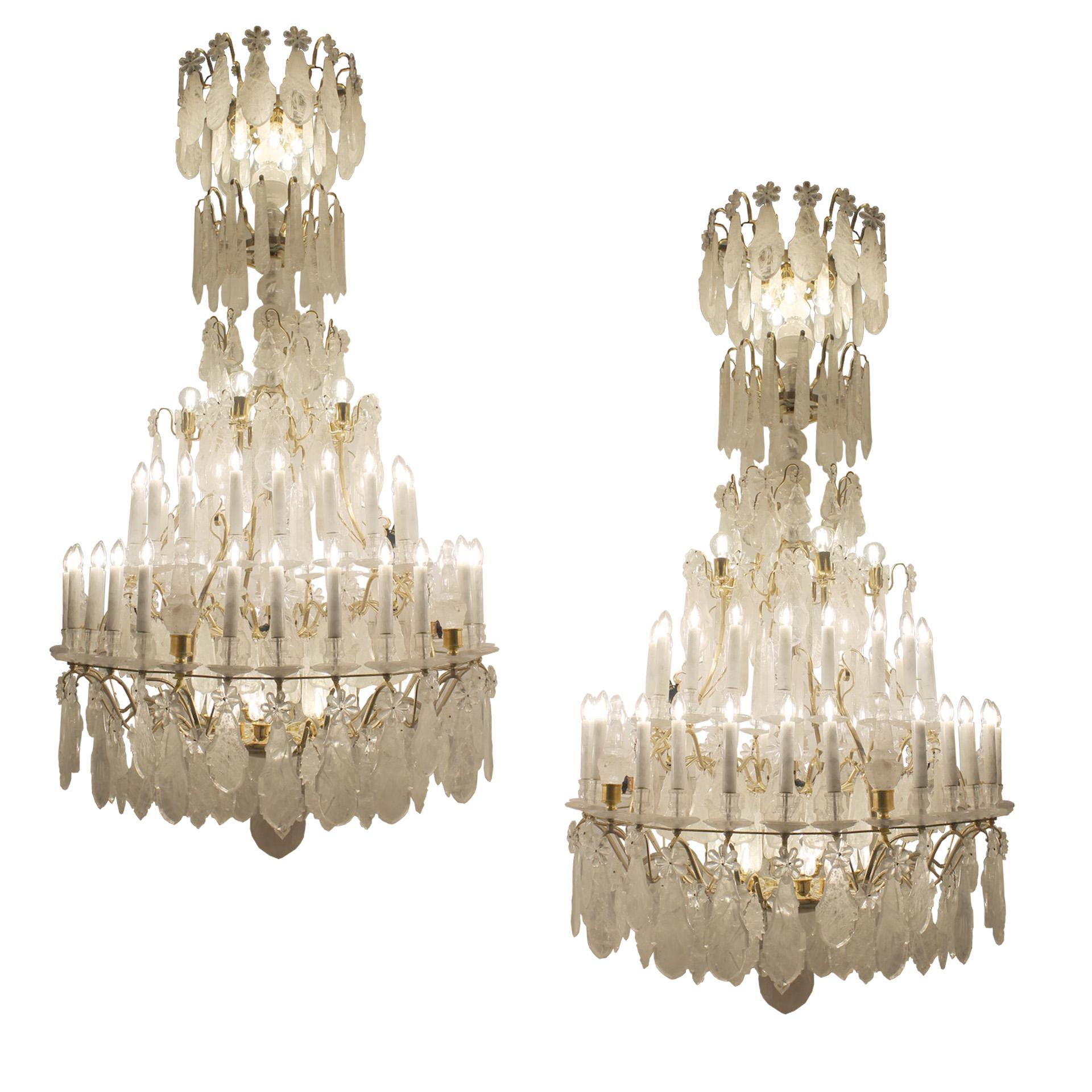 Exceptionnelle paire de lustres en cristal de roche dans le style classique Louis XV avec des dimensions inhabituelles de 2,4 m de hauteur, 1,2 m de diamètre. Chaque lustre est composé de 45 ampoules principales et de 16 ampoules pygmées. Toutes les