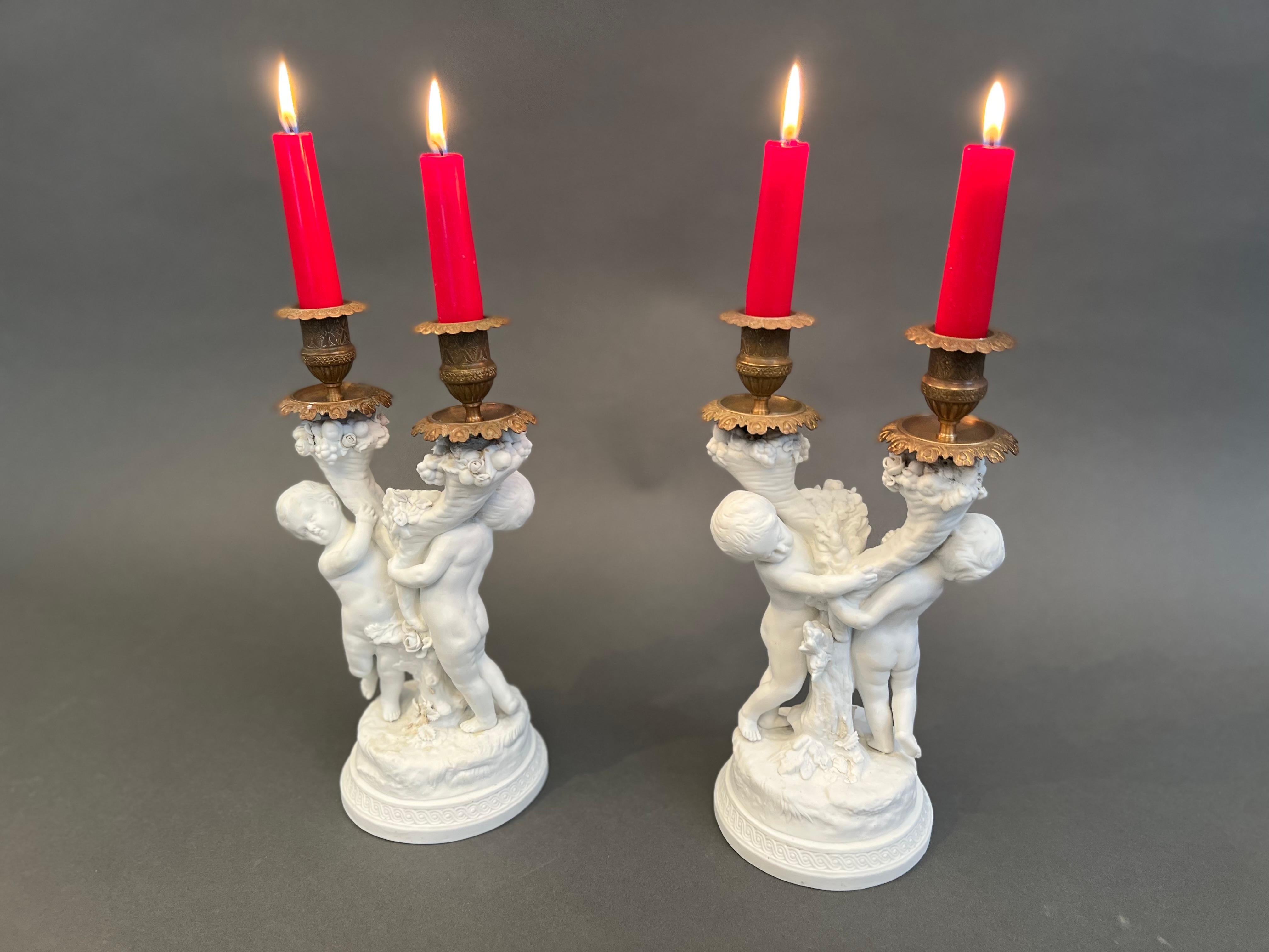 Siamo lieti di presentare una splendida coppia di portacandele di Sèvres realizzati tra il 1758 e il 1815, che combinano l'eleganza della porcellana biscuit e del bronzo. Ogni pezzo presenta due bracci di luce, squisitamente ornati da cherubini che