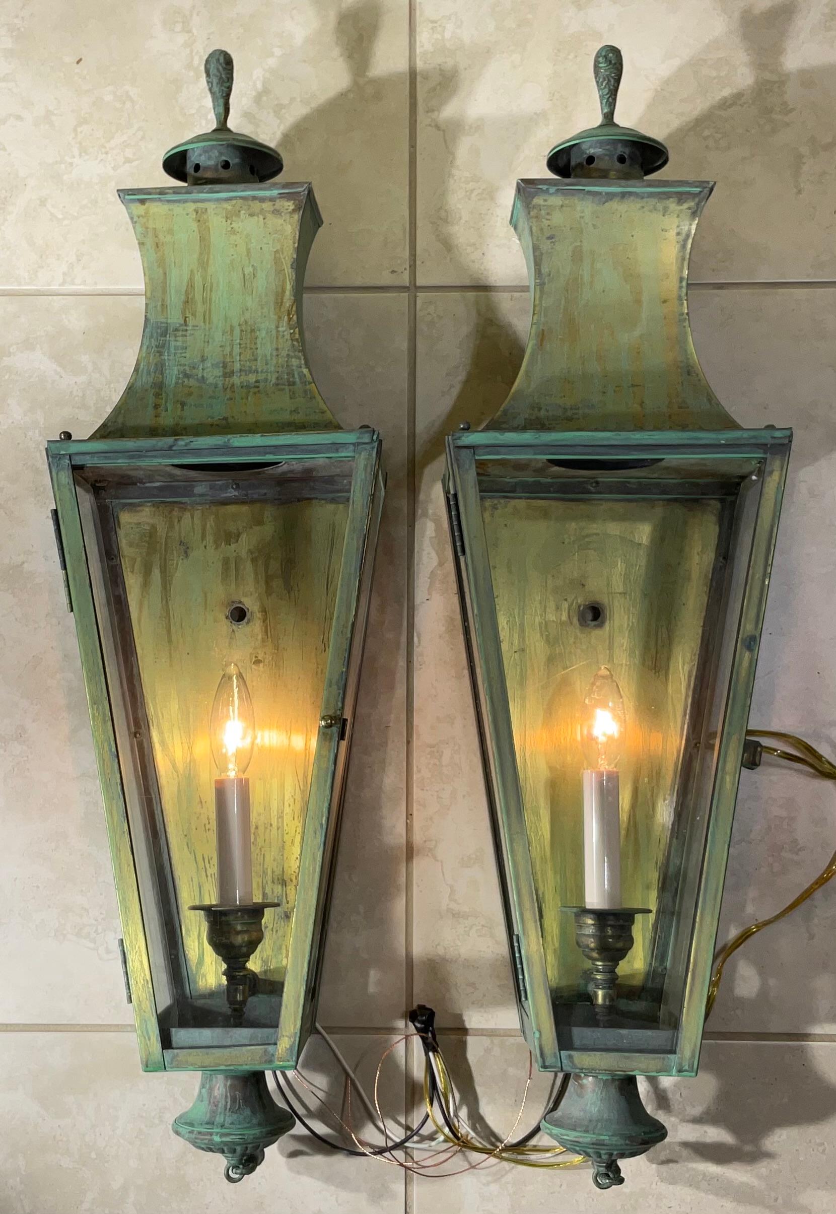

Elevate your home's exterior or interior with this elegant matching pair of large vintage solid brass wall lanterns. These lanterns are a testament to classic, timeless design, reminiscent of traditional colonial, carriage, or nautical lighting