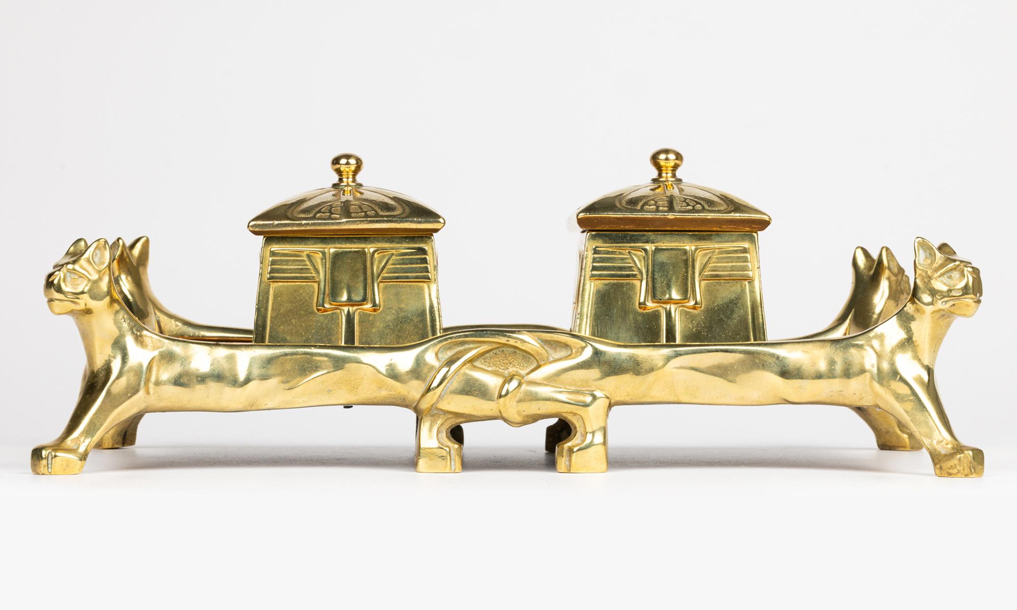 Un portaoggetti da scrivania in ottone e rame di eccezionale qualità, in stile Art Nouveau egiziano, sollevato su quattro piedi a forma di puma e risalente ai primi anni del XX secolo. Probabilmente francese, il supporto da scrivania è di forma