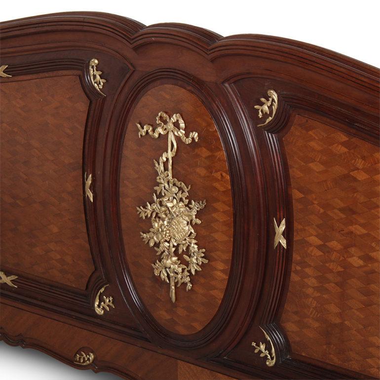 Exceptional quality French Louis XV-style bed in mahogany, having a shaped carved frame, the headboard and footboard with inset parquetry, the whole embellished with finely-cast ormolu mounts. The bed is unusually large for an antique bed – will