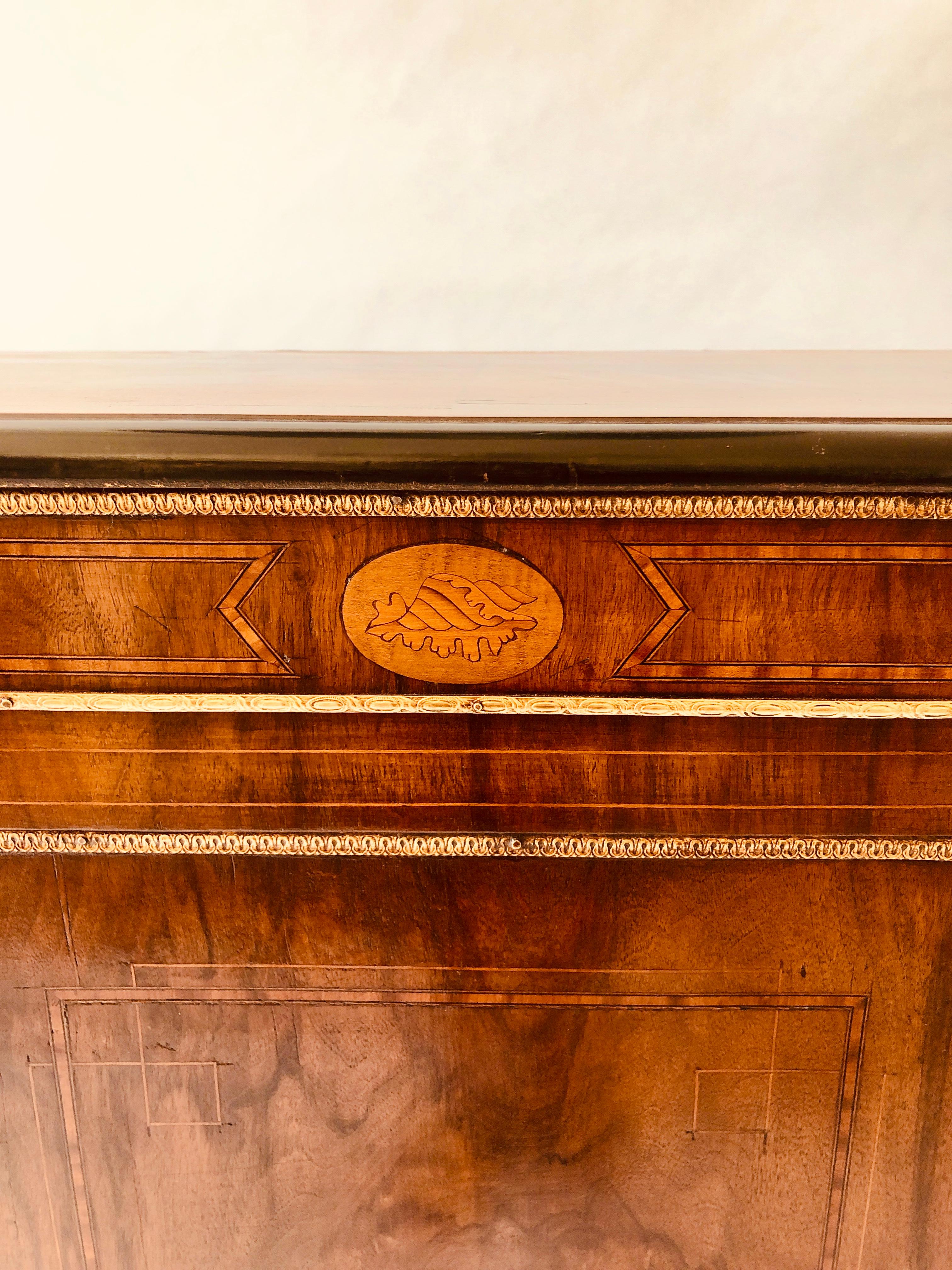 Exceptional quality Victorian burr walnut inlaid credenza having a burr walnut top with a thumb moulded edge. One door to centre with a Fine burr walnut inlaid panel flanked by two shell designs. Bowed glass opening doors to sides with the original