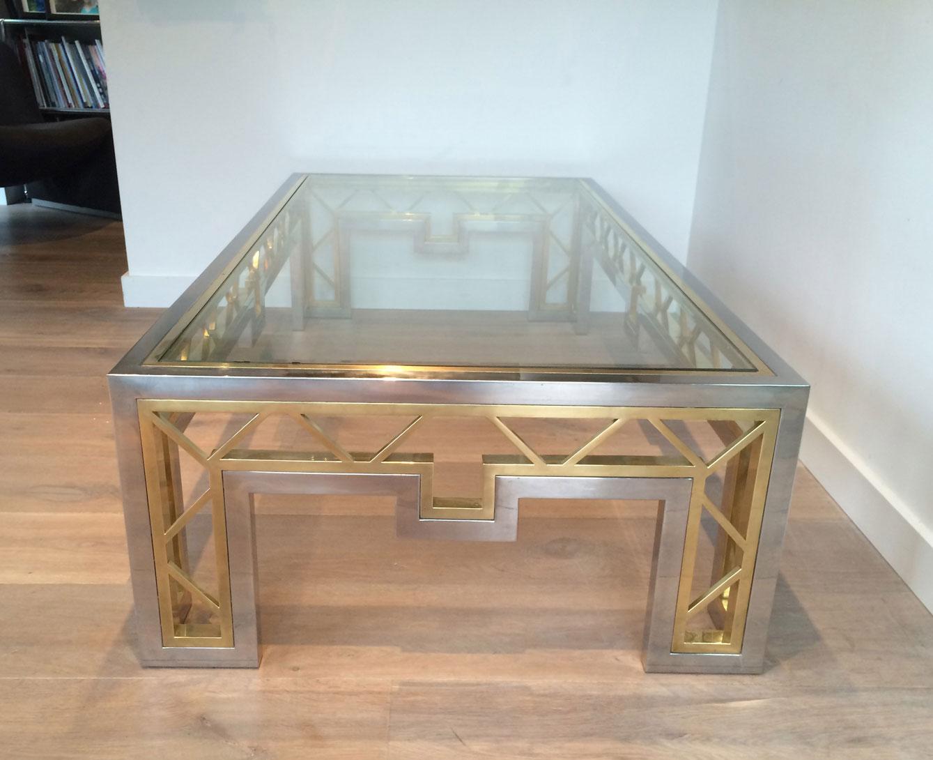 This exceptional and rare large coffee table is made of a very nice combination of chrome and brass. The brass is included in a chrome frame and worked as a nice geometrical design. 