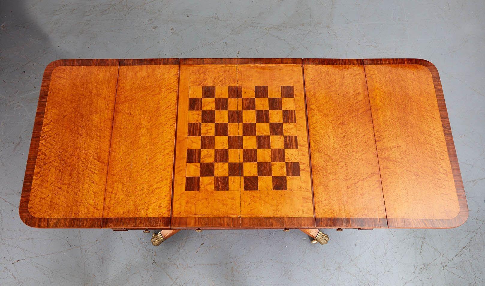 Très belle table de canapé Regency en loupe d'érable et palissandre, le plateau avec un puits coulissant révélant un plateau de backgammon avec un plateau réversible échecs/chiquet, flanqué de deux tiroirs et de deux feuilles tombantes et reposant