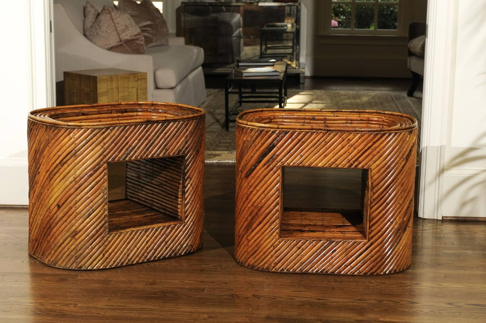 A stunning pair of restored bamboo display end tables, circa 1975. Stout mahogany frame construction completely veneered in bamboo. Clever display compartments at the tabletop and centre. Exquisite craftsmanship and quality - aged to absolute