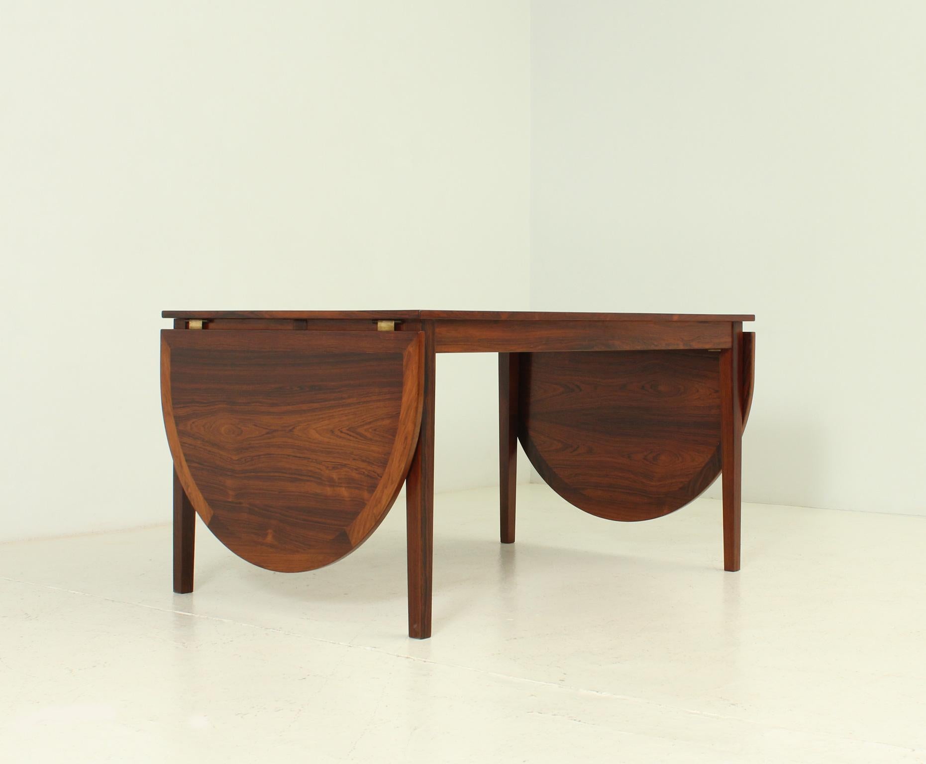 Exceptional dining table designed by Kai Winding in 1960's for Slagelse Möbelvaerk, Denmark. Hardwood with brass and leather fittings with two removable drop leaves. Easy opening with one or two leaves with 130/185/240 cm long when open.
   