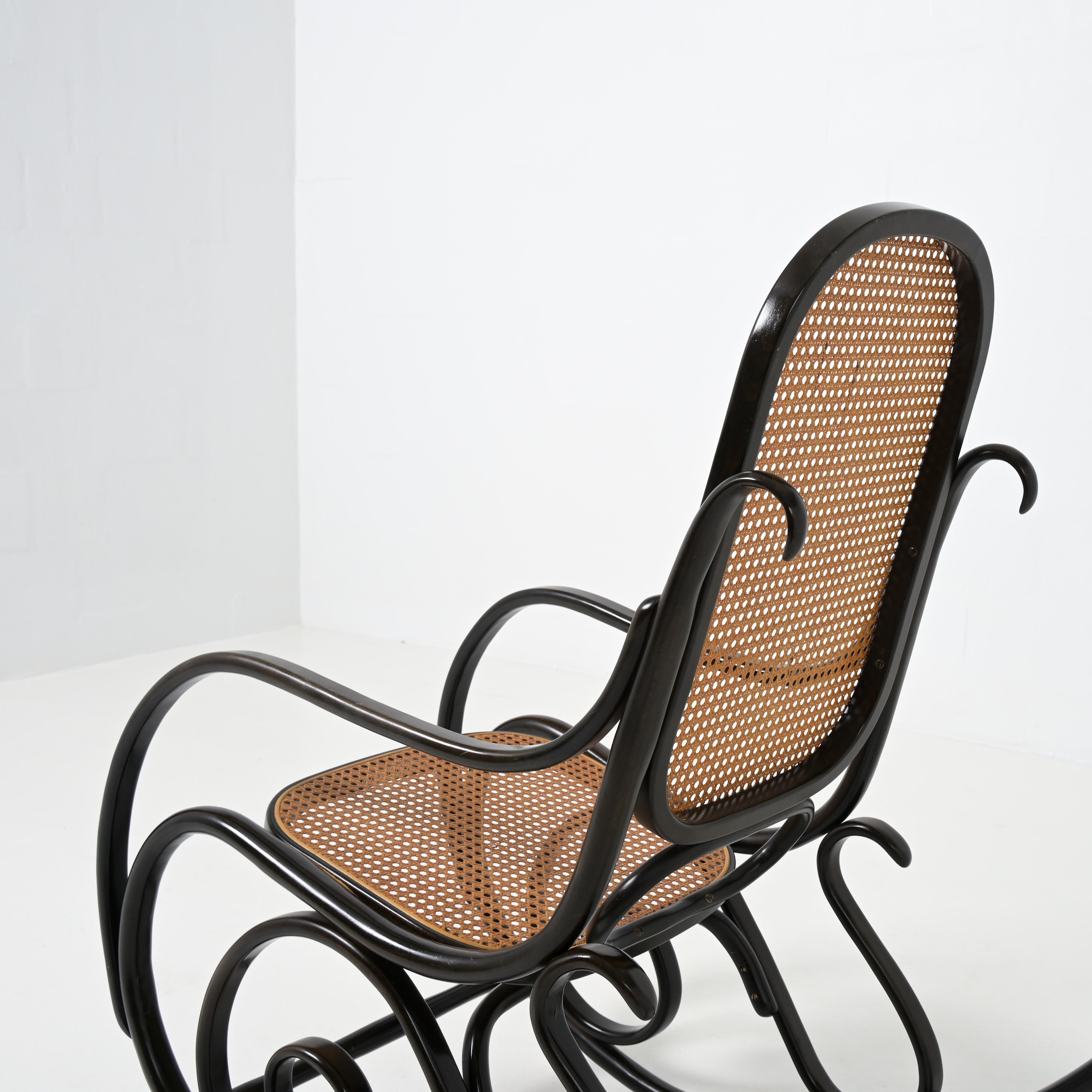 This old authentic rocking chair was designed Michael Thonet and manufactured by Thonet. It was in the catalogue of 1904. It is a design classic.

This dark brown rocking chair is in very good vintage condition with normal signs of age and use. The