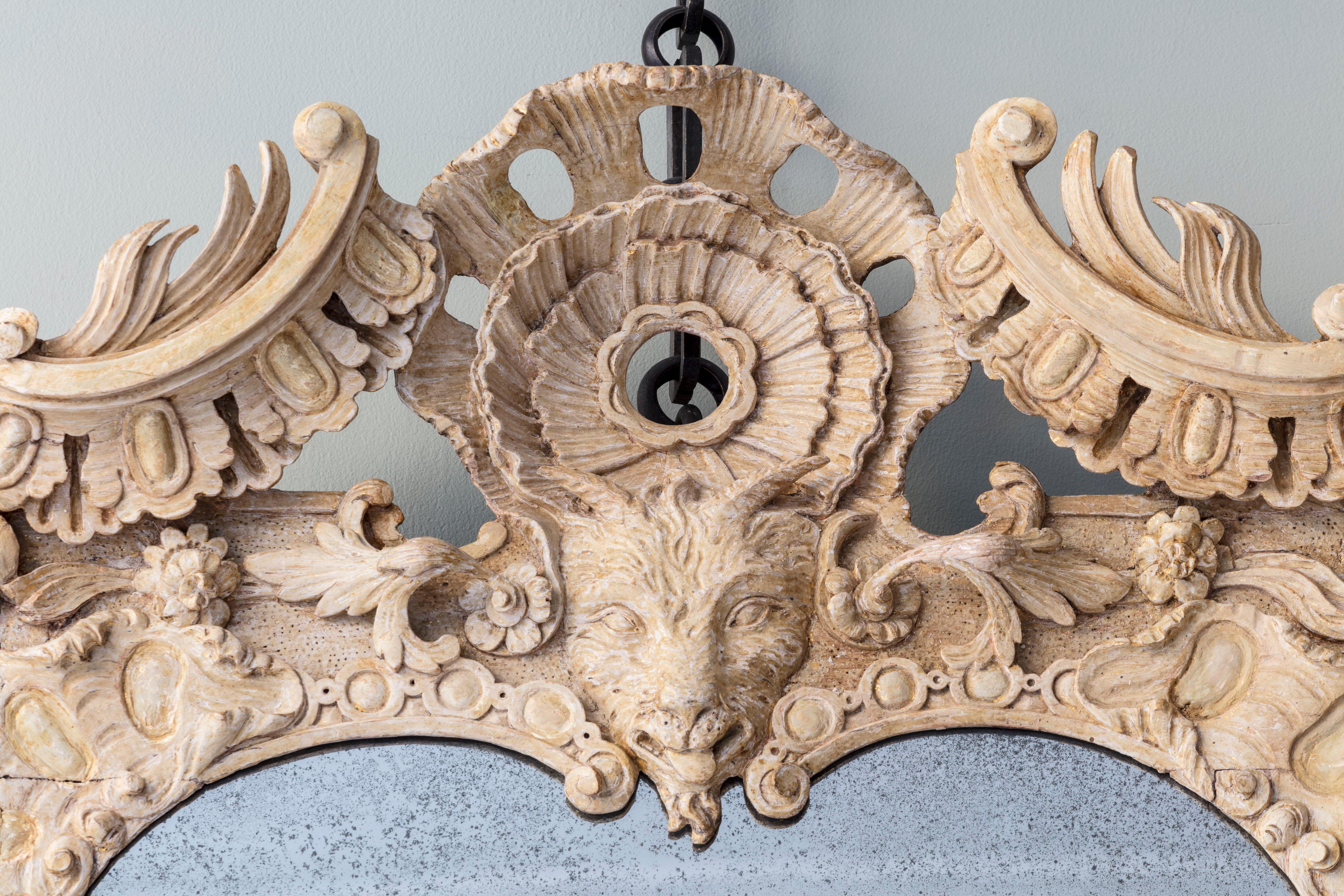 An Exceptional Rococo Carved Giltwood Pier Mirror with Central Goat Mask with profuse scrolling pediment enclosing foliate and shell cartouche and central goat mask, within scrolling cornucopia and acanthus border, and pierced shell apron. English