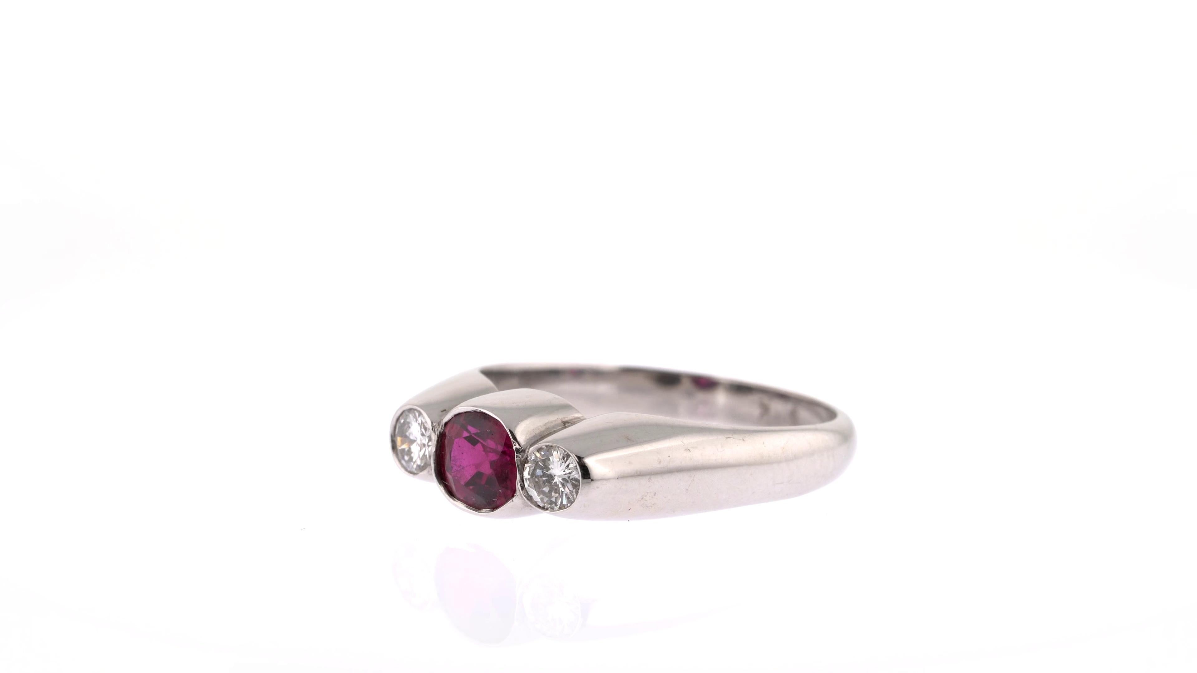 Brighten up any occasion with this delicate ring, whose main stone adds a burst of colour to an otherwise minimal piece. The lively red ruby is cut in an oval shape and sits between two white round diamonds on a clean white gold band, meaning there