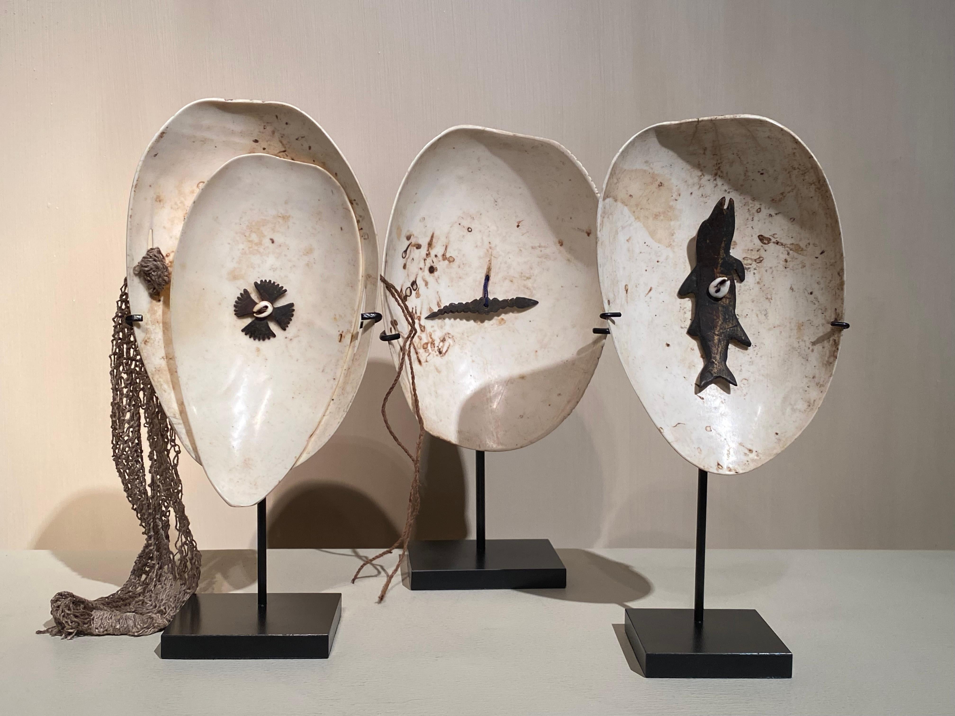 An exceptional set of 3 Shell objects from Papua New Guinea,
made as ornaments used in the hair or as decoration of the body,
decorated with hand carved figures made out of coconut or wood,
small shells and fibres,
good patina and shine of the