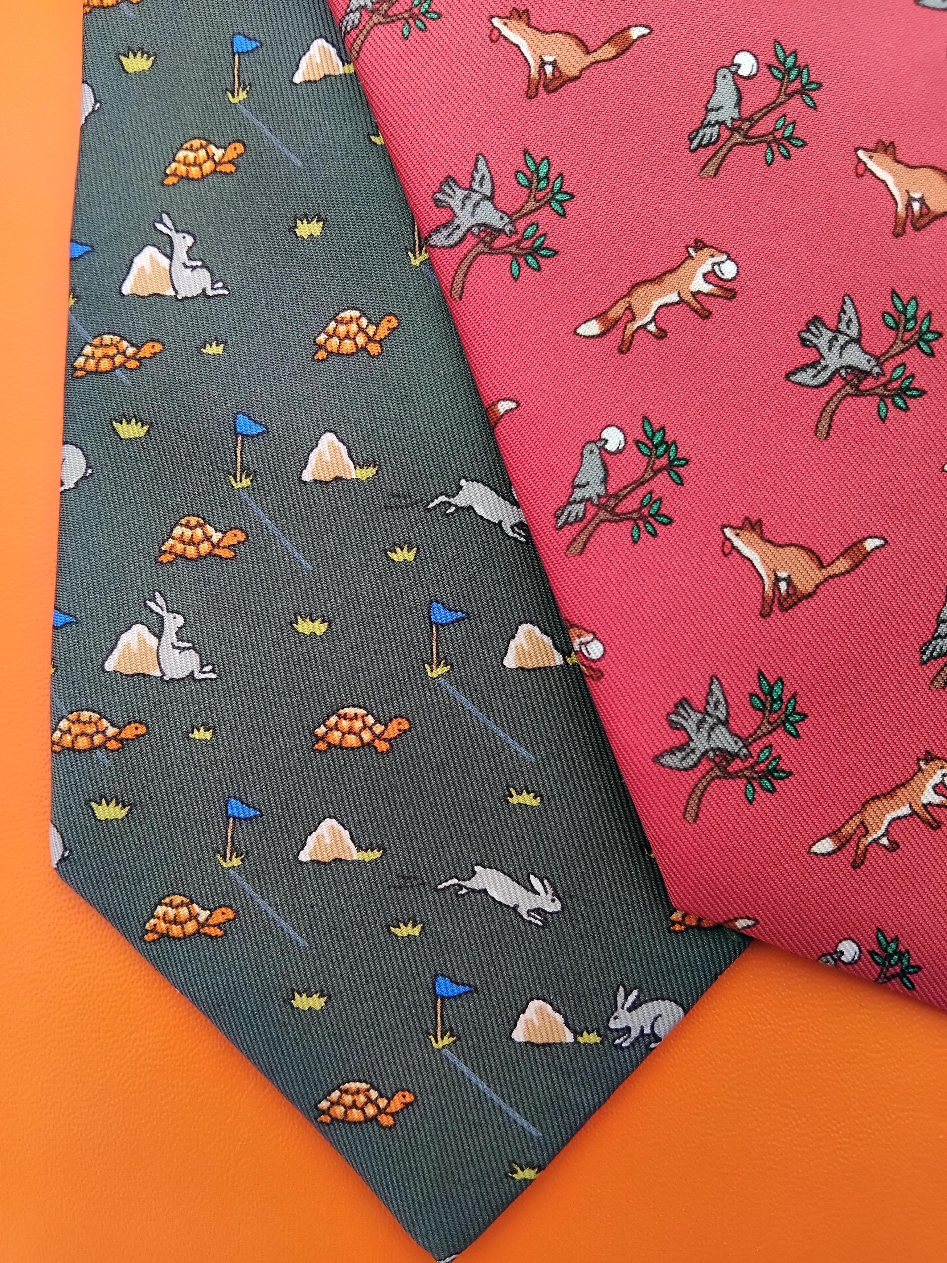 Rare lot de 4 cravates authentiques Hermès

Impressions : Les Fables de La Fontaine

De gauche à droite :

1. Le lièvre et la tortue en vert, gris, orange, bleu. 100% soie. Doublé de soie verte unie. Avec étiquette d'entretien. 148 x 9,3 cm (58,27 x