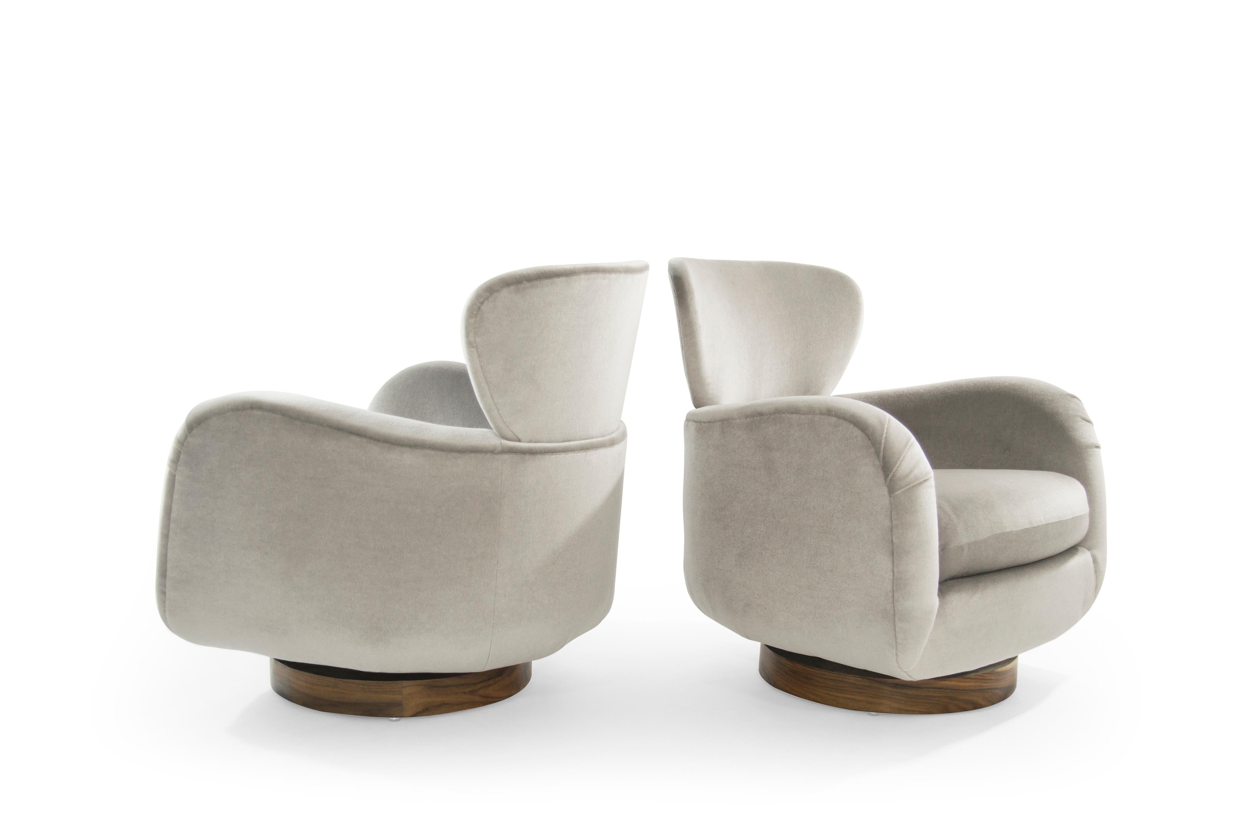 Important set of Vladimir Kagan for Directional pair of stylized wingback lounge chairs and ottoman. Sumptuously designed with enveloping curves and a large horned neck. Newly upholstered in Great Plains 
