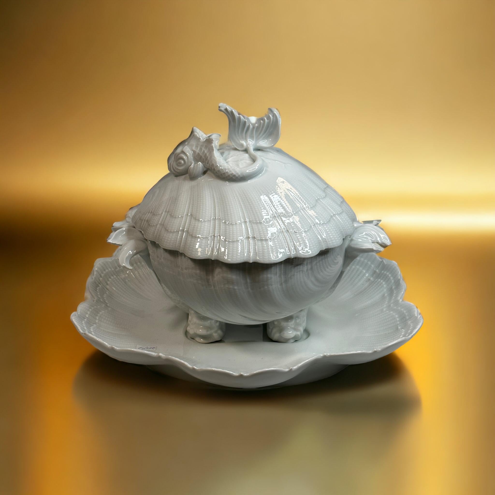 A gorgeous impressive soup tureen with its display in the shape of a shell and fish in white Limoges porcelain in perfect condition. Fantastic piece for each table. In used but still very good condition. A nice addition to any table or just for