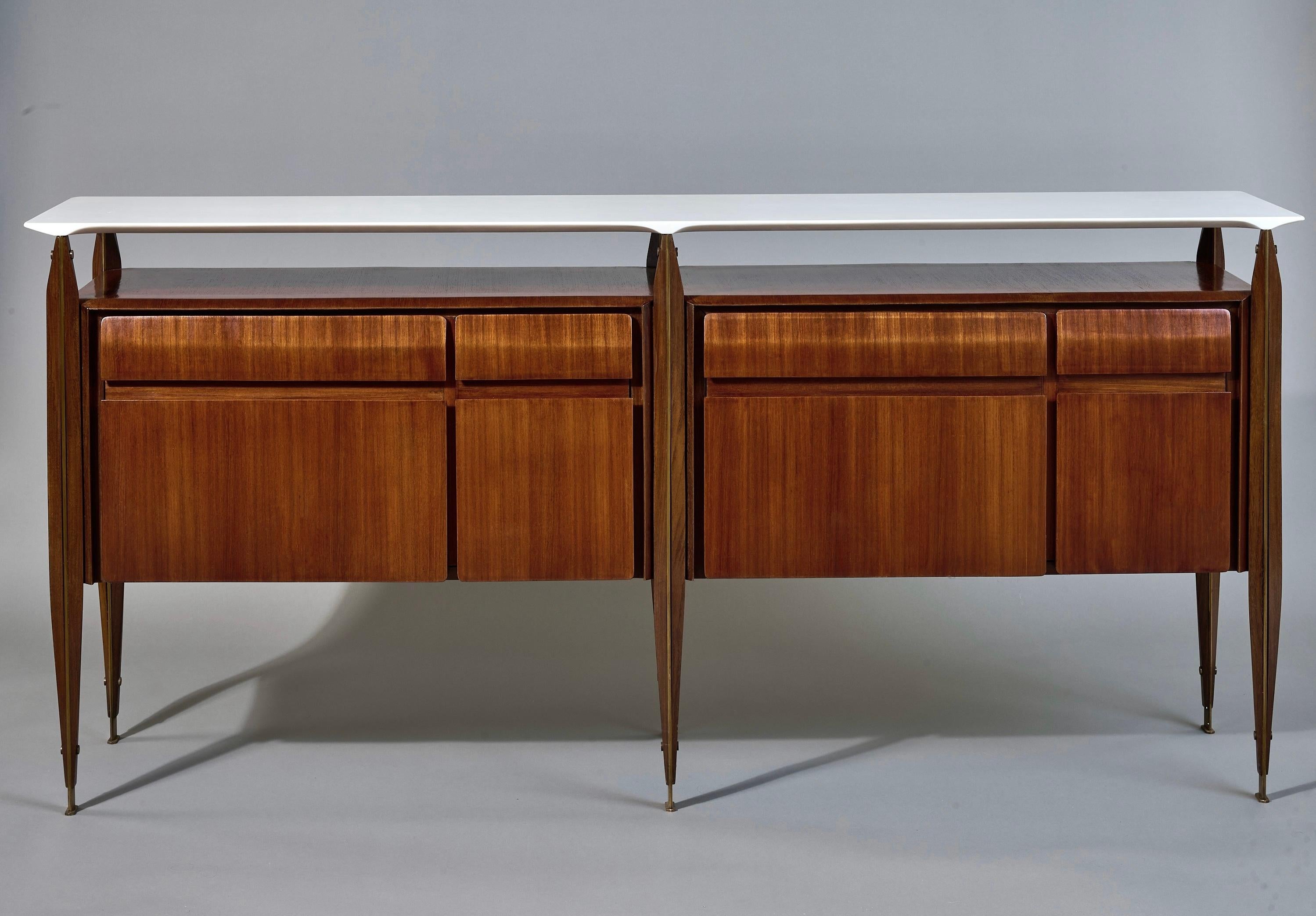 Italy, 1950's

A large and exceptional sideboard in rosewood with a floating white marble top and brass detailing. The cabinet features an elegantly soaring, three-dimensionally sculpted marble plateau with skillfully carved divots that gracefully