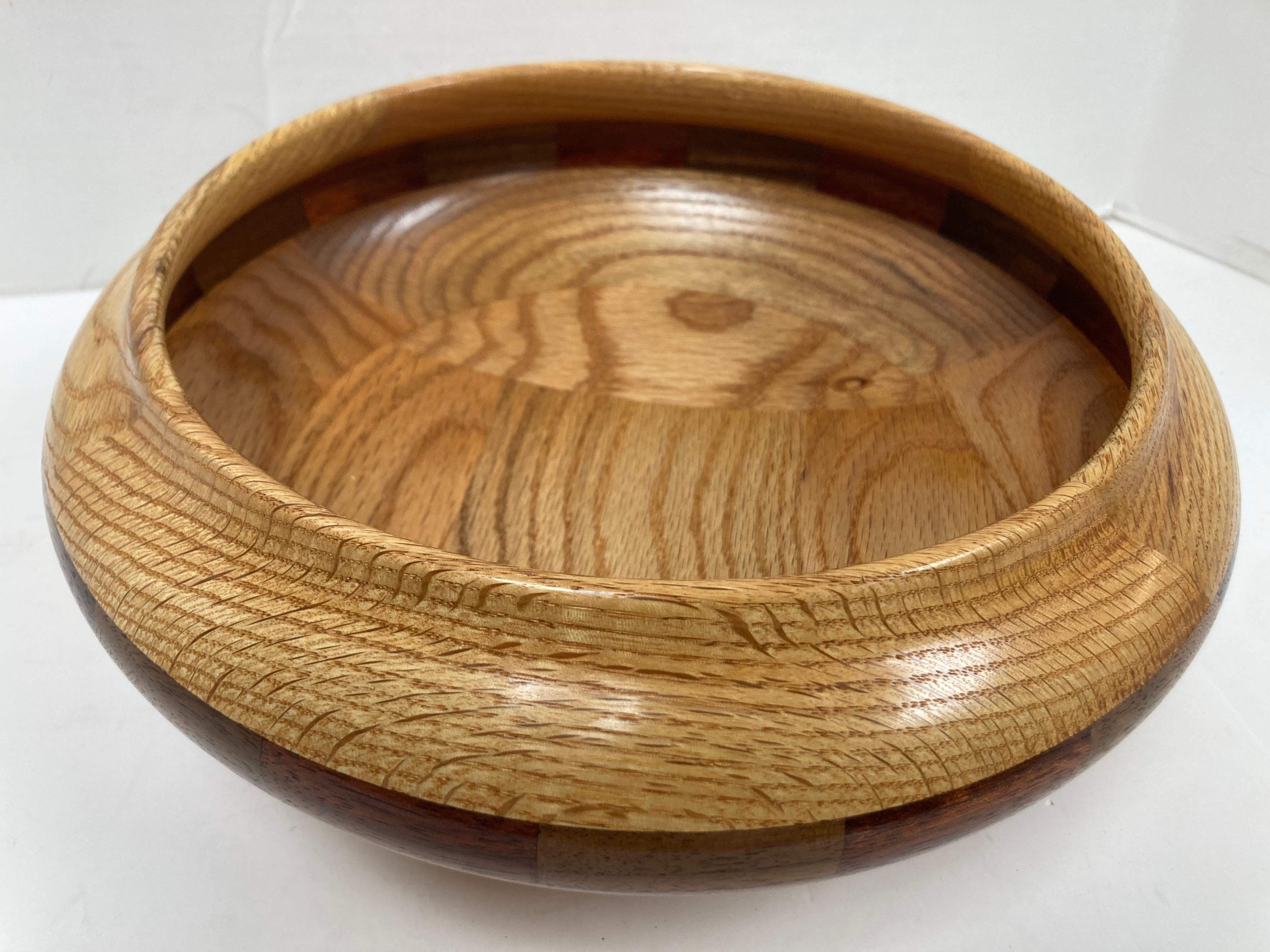 A very finely crafted signed bowl by New Mexican craftsman Joe H. King. With  a fine form somewhat reminiscent of Southwester Native American pottery, the primary wood is beautifully grained oak with an encircling band of various mixed woods of