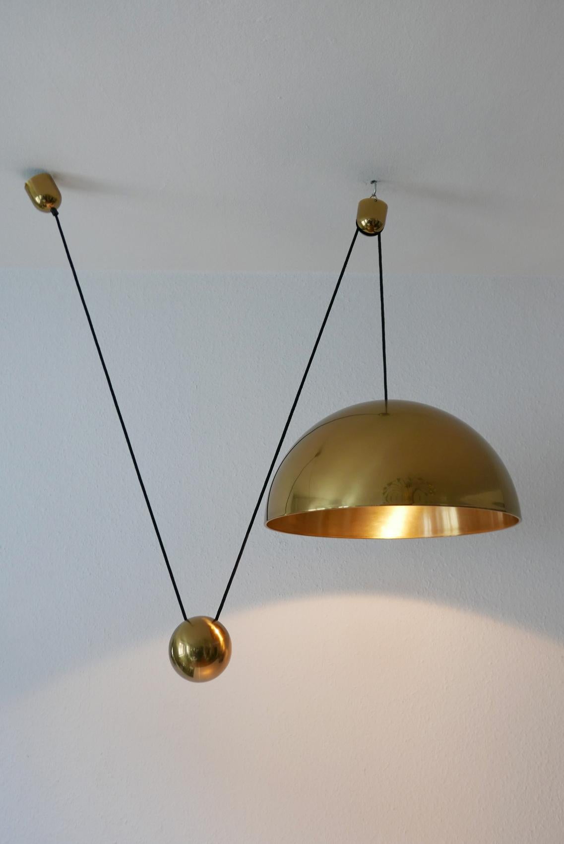 Elegant and extremely rare, large Mid-Century Modern counterweight pendant lamp Solan by Florian Schulz, Germany, 1980s.

Executed in solid polished brass. The lamp needs one E27 Edison screw fit bulb, is wired. It runs both on 110 / 230