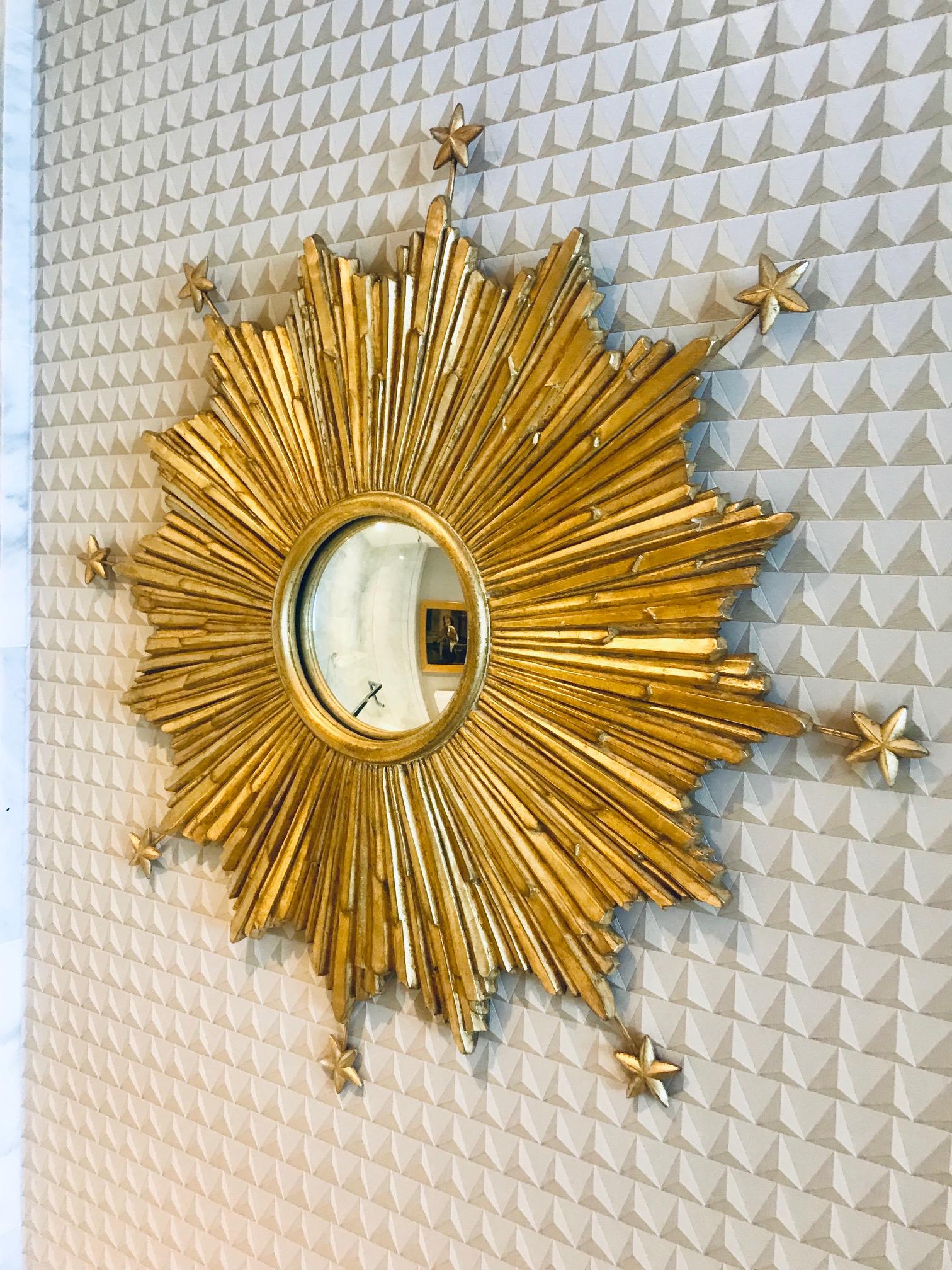 Exquisite sunburst mirror with extended star accents. Hand made by artisans using casting technique of wood, resin, and wire to create three dimensionality form. Features a central convex mirror and hand laid antique gold leaf finish.