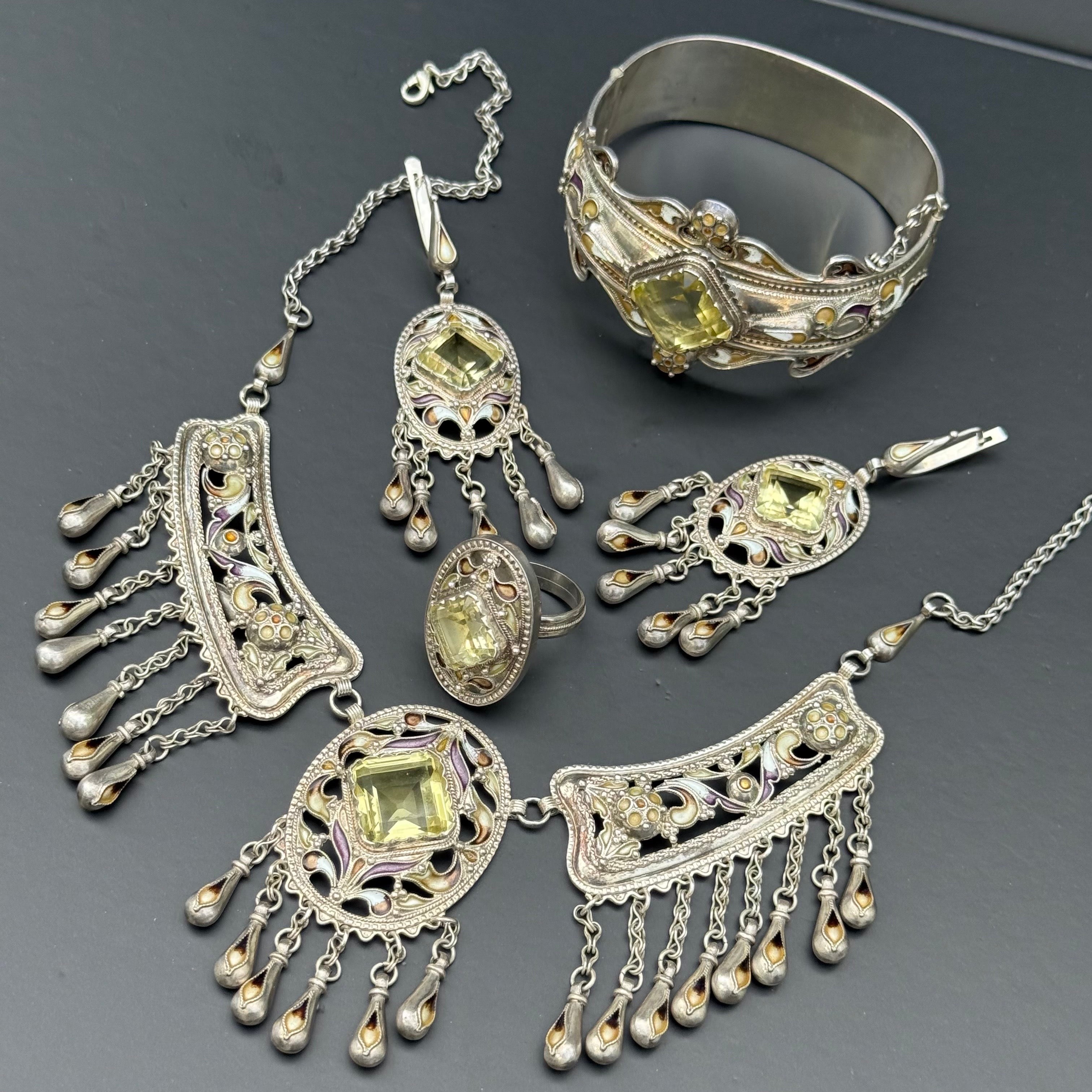 An exquisite four-piece vintage jewelry suite dating to the mid to late 20th century, likely of European origin. This remarkable set includes a bib-style necklace, hinged bangle bracelet, dangle earrings, and a matching statement ring—all crafted in