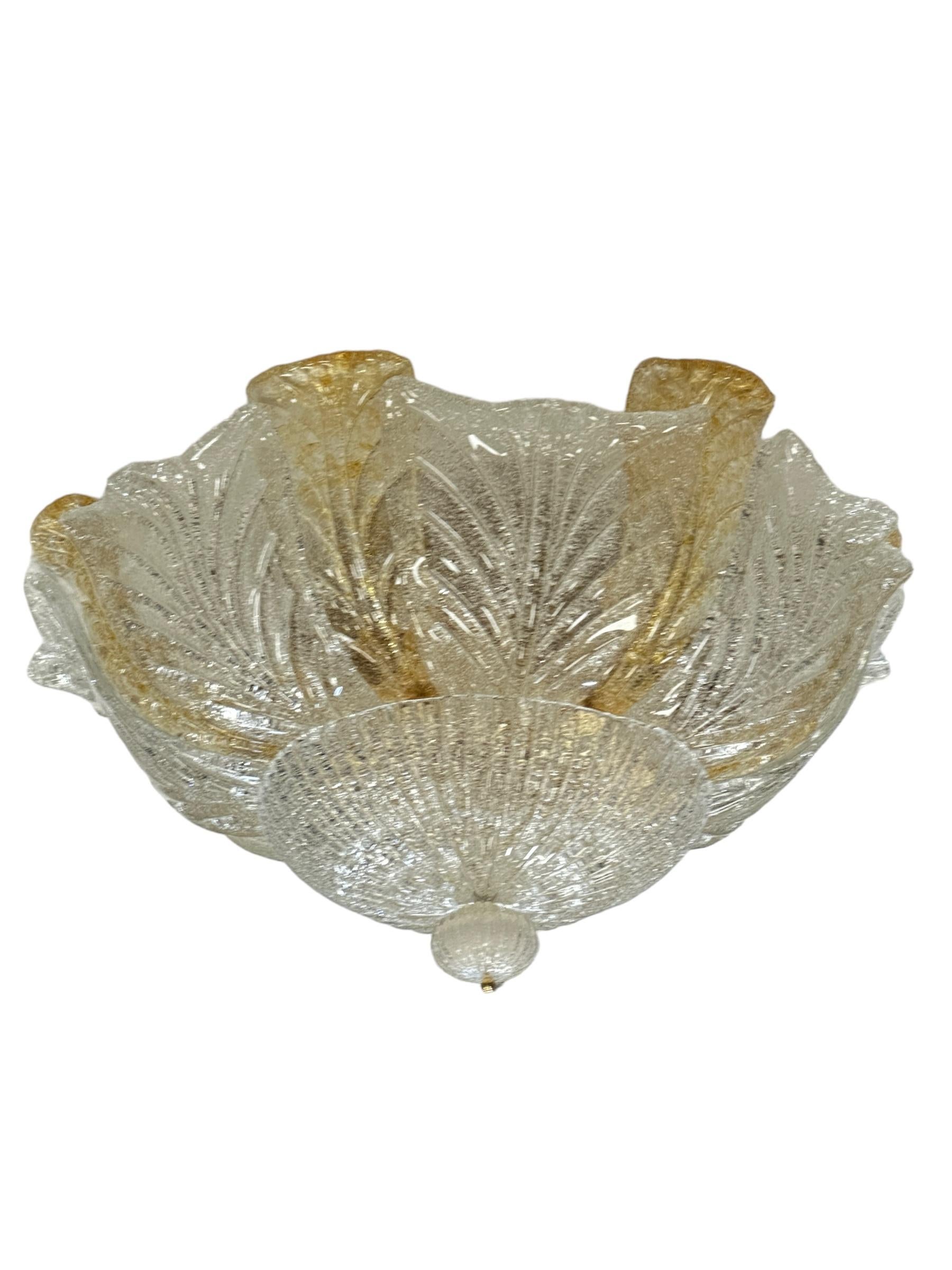 A large midcentury flush mounted Murano leaf glass chandelier, textured curved glass leaves on a large mounting plate with heavy metal ring. Fourteen curved discs of Murano glass, seven clear glass and seven gold flake smaller ones. The ceiling