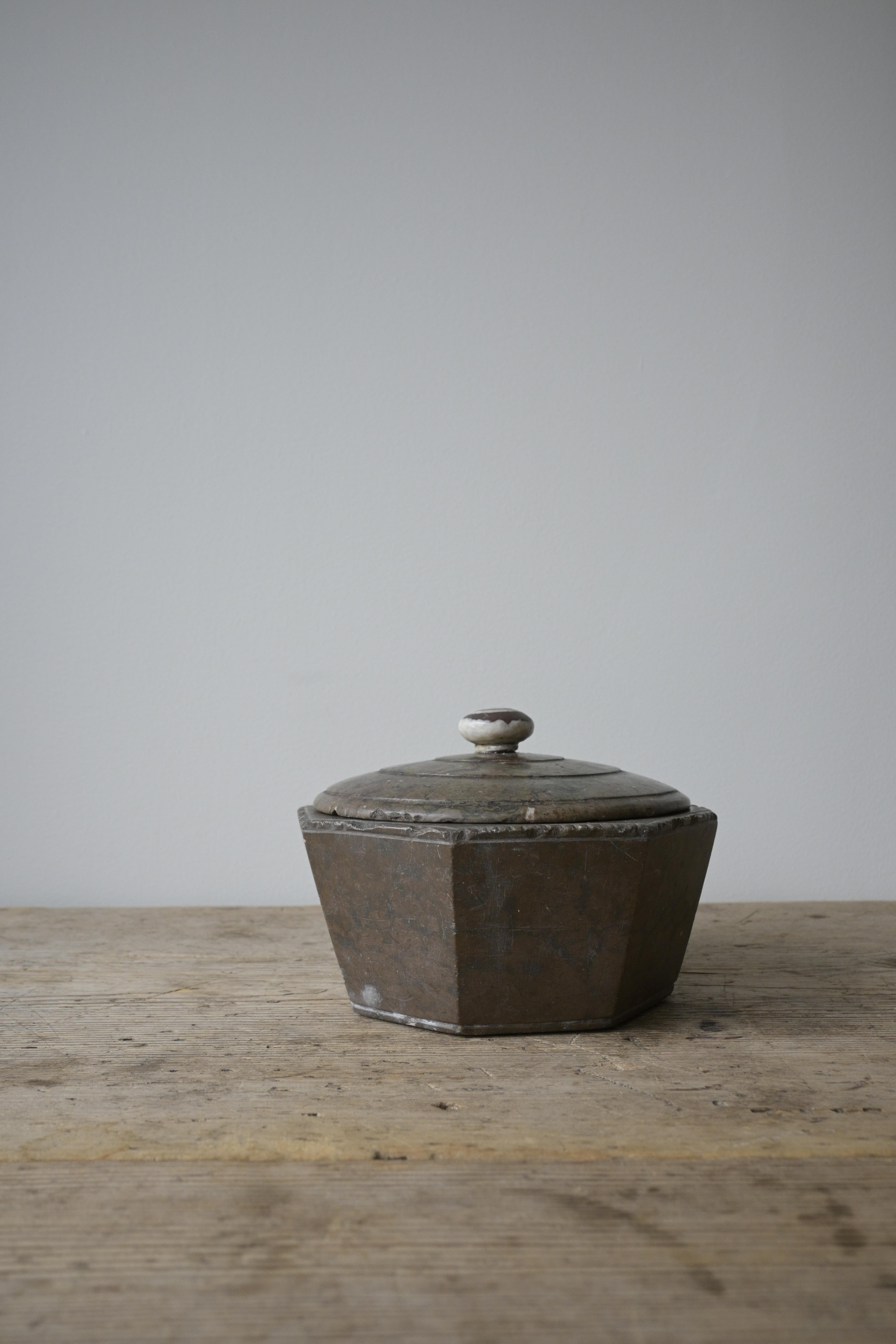 Exceptional Swedish Butter Box ca 1700-1830

Octagonal-shaped limestone box with a fossil knob.
Its carved lines and beautiful wear make it what it was centuries ago - a statement piece for any table.

Made out of Swedish limestone.

Height: 10.5