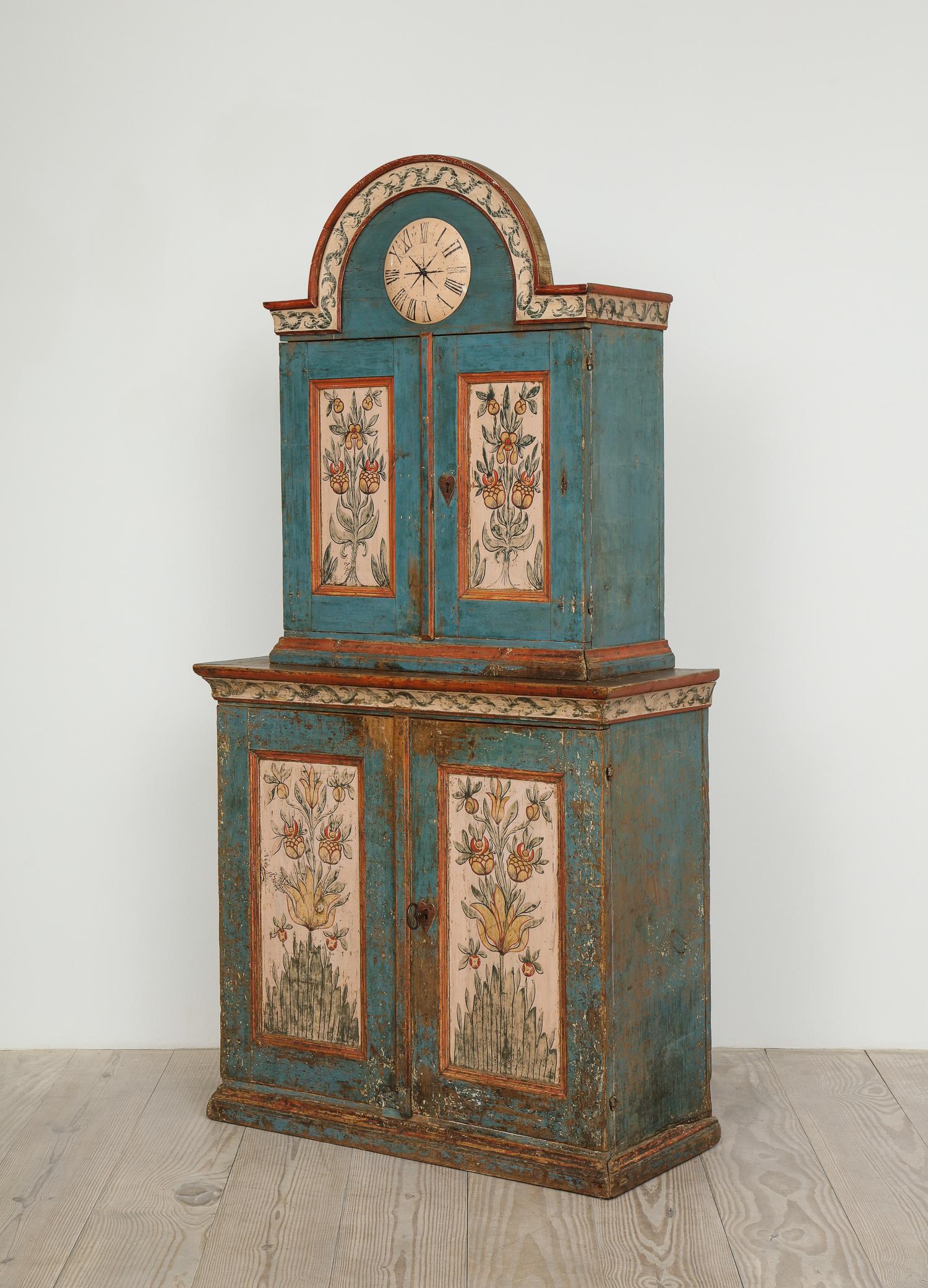 Exceptional Swedish (Skånkskåp) Allmoge cabinet with a faux clock and exceptional original painting, origin: Dalarna, Sweden, circa 1800.

All original paint depicting symmetrically branching flowering plants, climbing ivy and charming, original