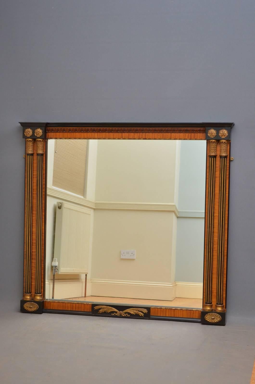 Sn4312, stylish turn of the century overmantel mirror in satinwood, having ebonized cornice above a finely carved detail and original mirror plate with some foxing flanked by ebonized and gilded half columns and gilded flowers. This antique mirror