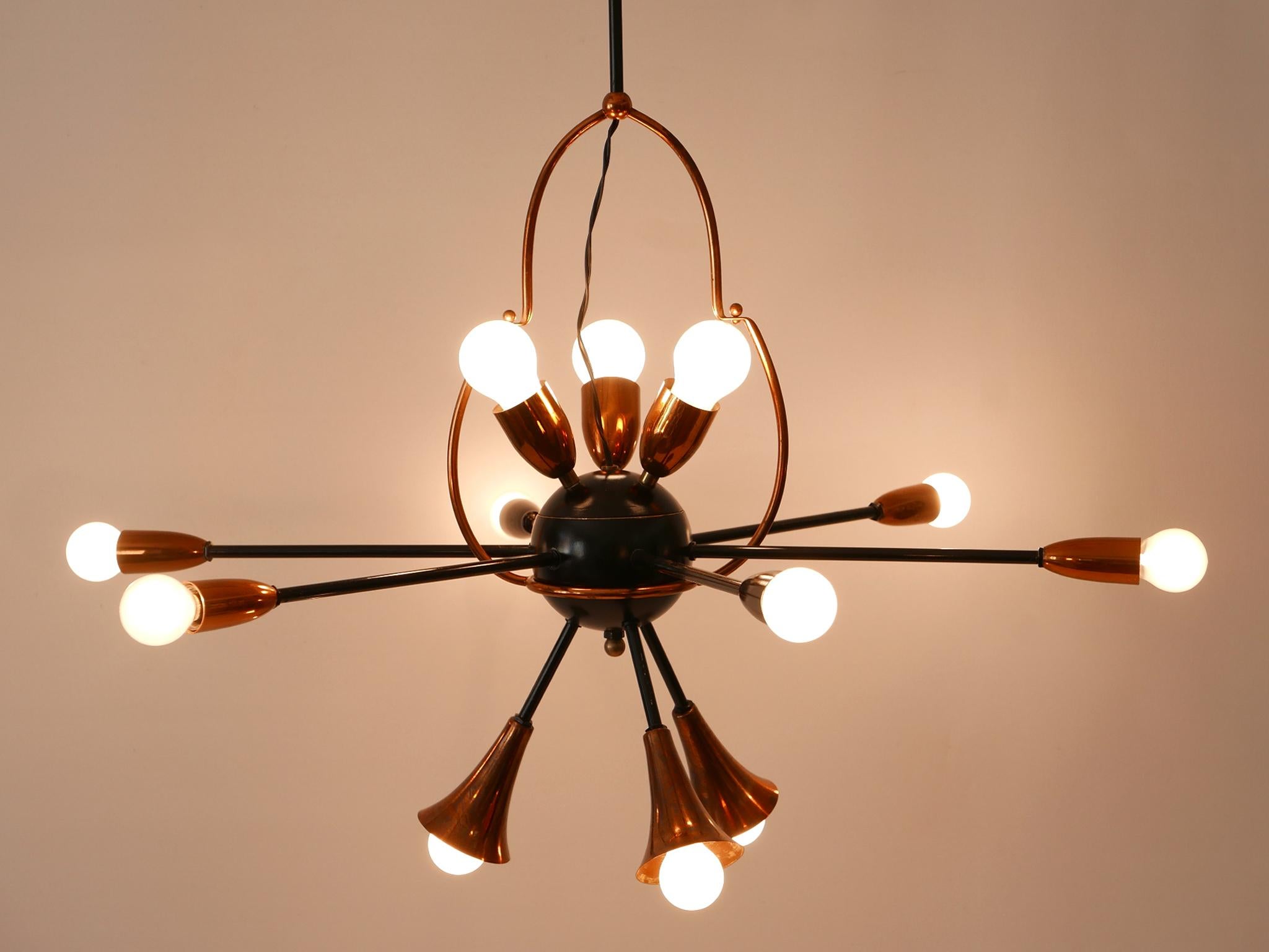 A breath taking design object. Extremely rare, lovely and highly decorative Mid-Century Modern twelve-flamed sputnik pendant lamp or chandelier. Designed and manufactured probably in Austria, 1950s.

Executed in copper, brass and metal, the pendant