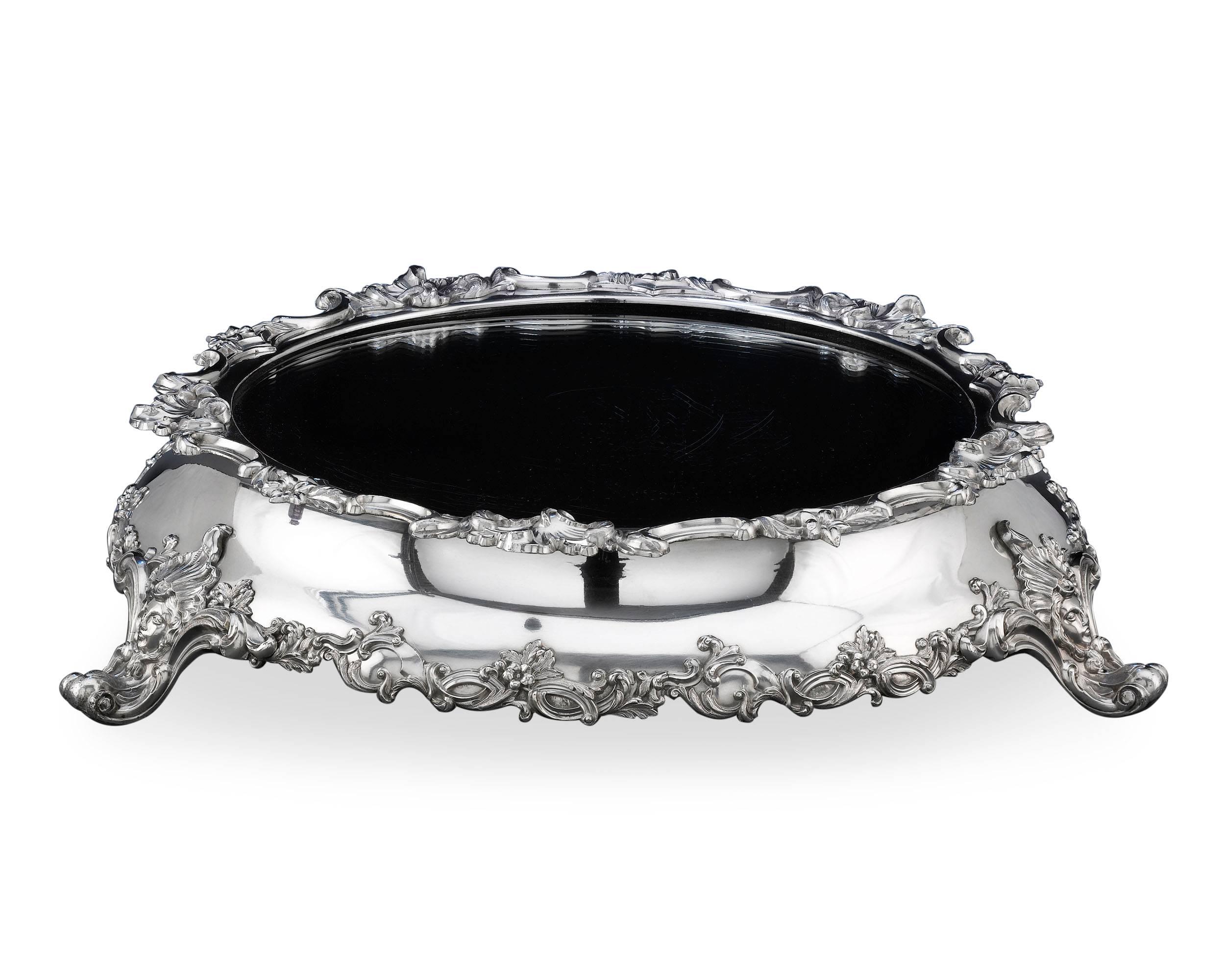 This stunning silverplate plateau is a remarkable example of Victorian design. Dynamic decorative accents of exceptional quality, depicting classic Rococo motifs of scrolls and acanthus leaves, are applied around the rim of the mirrored surface and