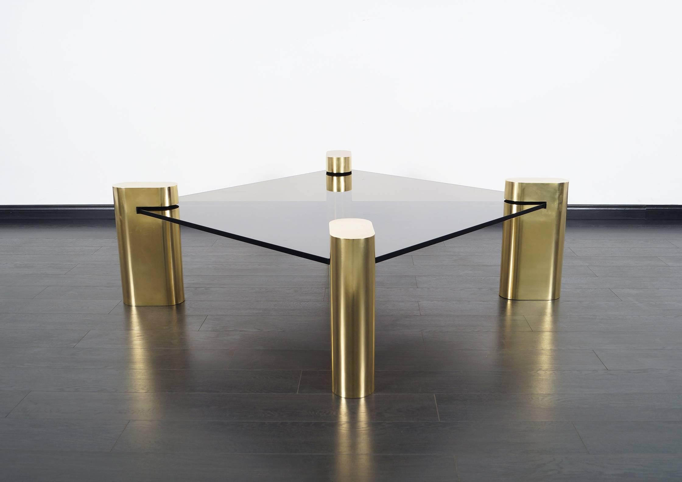 This exceptional rare brass and glass coffee table in the style of Karl Springer.