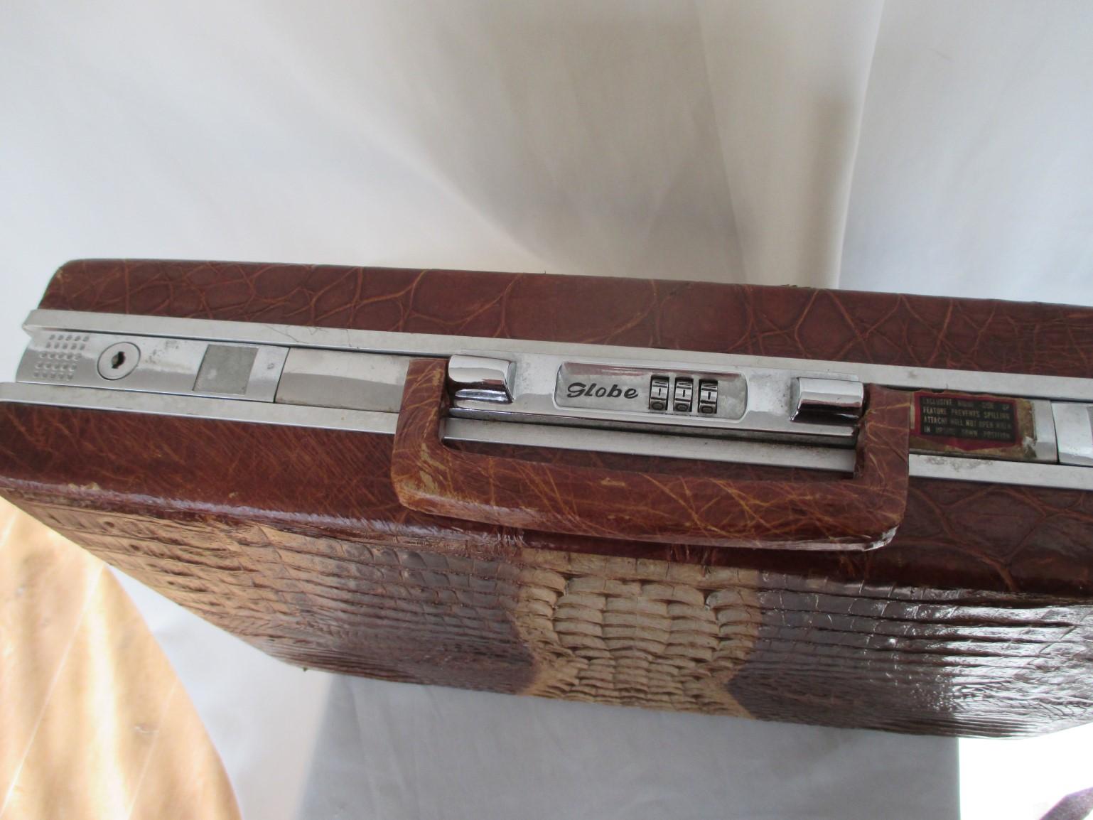 Collectors-item
Rare hard-sided attache case made of brown hornback crocodile skin with silver hardware.
Interior is leather with pockets and with hidden combination locks.
Marked:  Globe
Measurements: 43 cm x 31 cm x 9 cm

Please note that vintage