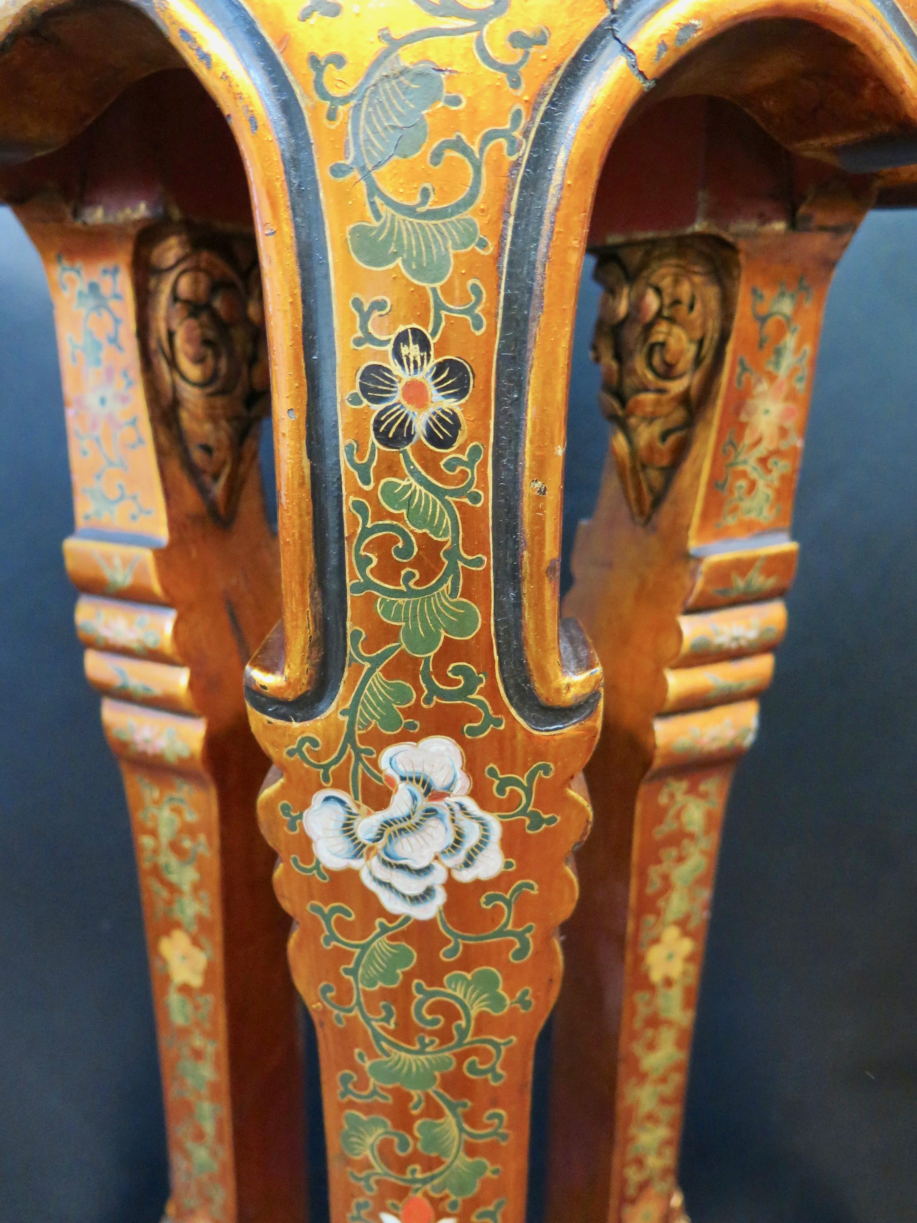 This rare Chinese pedestal dates from circa 1900 and is designed with bowed legs in carved teak. The pedestal is beautifully hand decorated with detailed and colorful lined florals that dominate its overall appearance. These floral decorations are