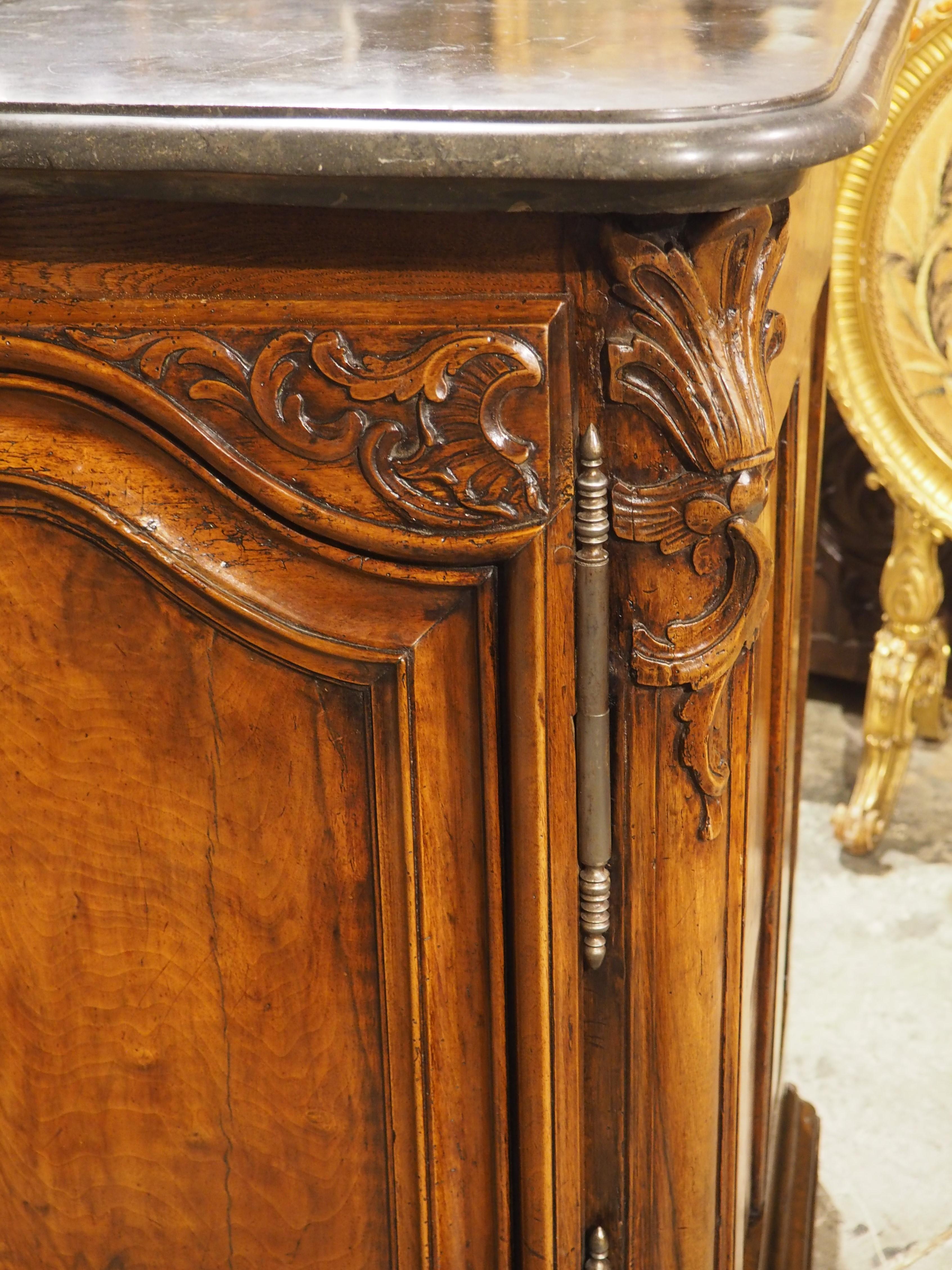 A rare find in today’s day and age, this walnut buffet with original pierre de st cyr stone top is in exceptional condition. Hand-carved circa 1715 in Lyon, France, this wonderful buffet has a deep, rich brown patina, offset by a black marble with