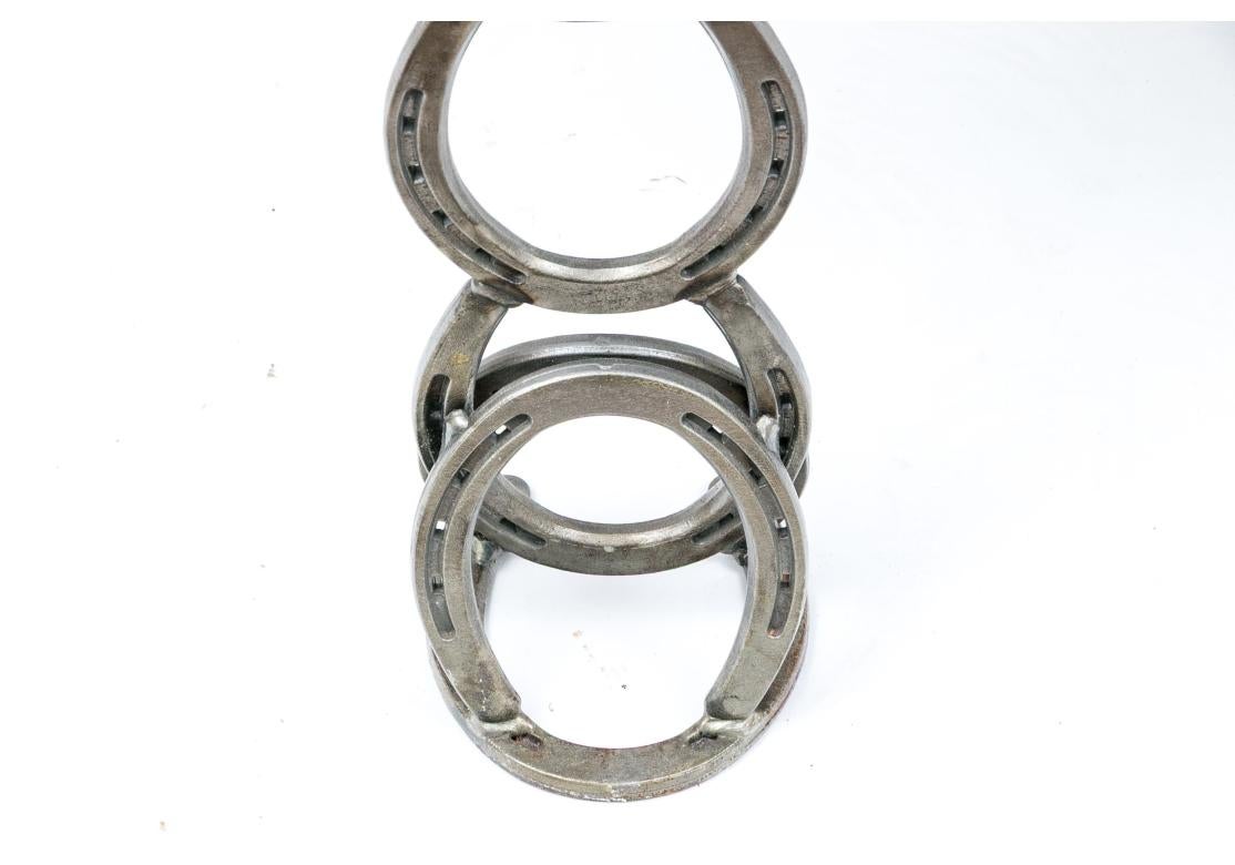 Une vitrine très bien réalisée sur le thème de l'Ouest avec des chevaux en acier découpé, des pieds en fer à cheval et des poignées de fusil. Le plateau élévateur est muni d'un loquet et d'une serrure. Clé fournie. S'ouvre pour révéler un grand