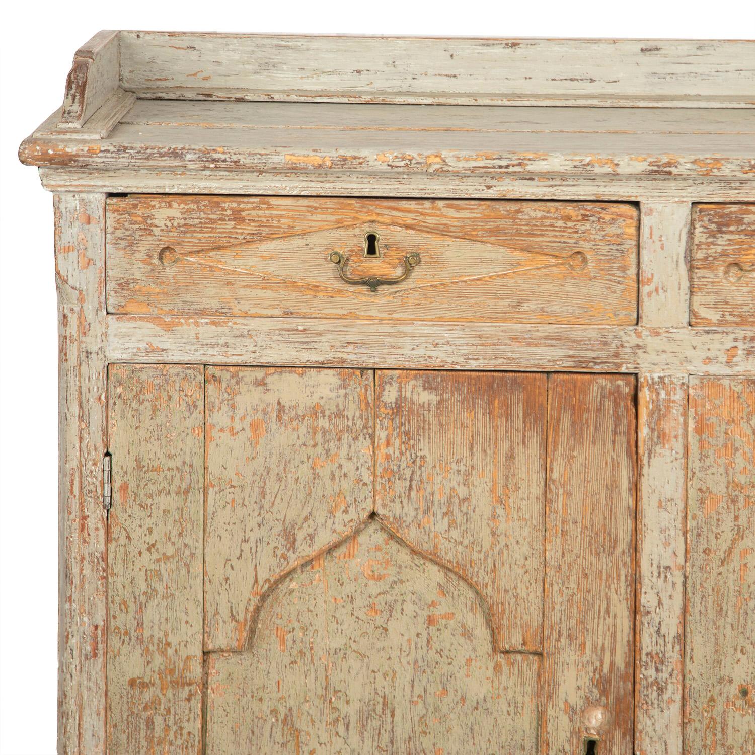 Exceptional wide Swedish buffet in wood from Jämtland, with a carved gallery top. Three drawers with original hardware, and beneath, three doors with decorative carved Gothic design open to useful storage space.