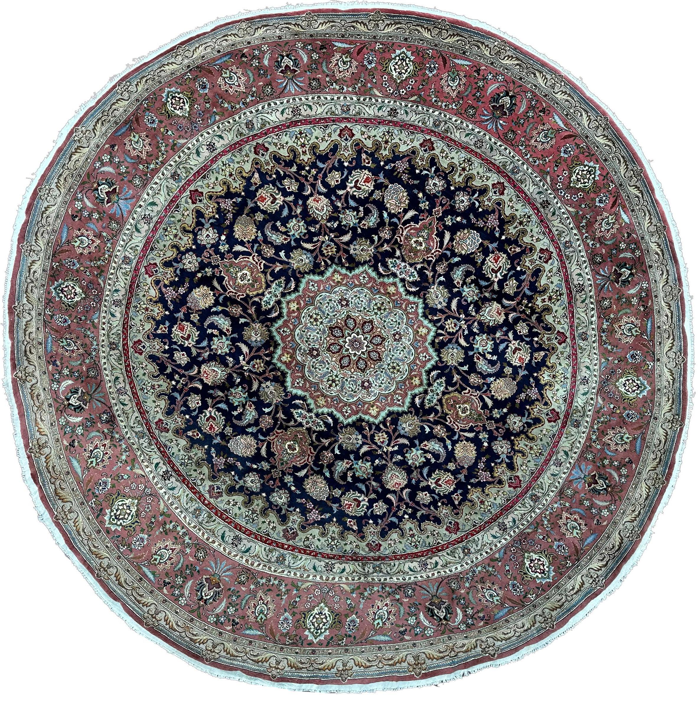 Dieser elegante runde Perserteppich aus feiner Korkwolle und Seide zeichnet sich durch ein ausgewogenes florales Medaillonmuster und eine außergewöhnliche Klarheit des Gewebes aus. Ein raffiniertes Einzelstück, das sich ideal für traditionelle oder