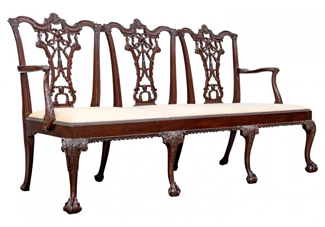 A very fine Georgian Bench with intricate and detailed carving and magnificent traditional English form.  The solid Mahogany Bench has three independent removable seats custom upholstered in a raised Chevron pattern in Tan and Cream. The Bench frame