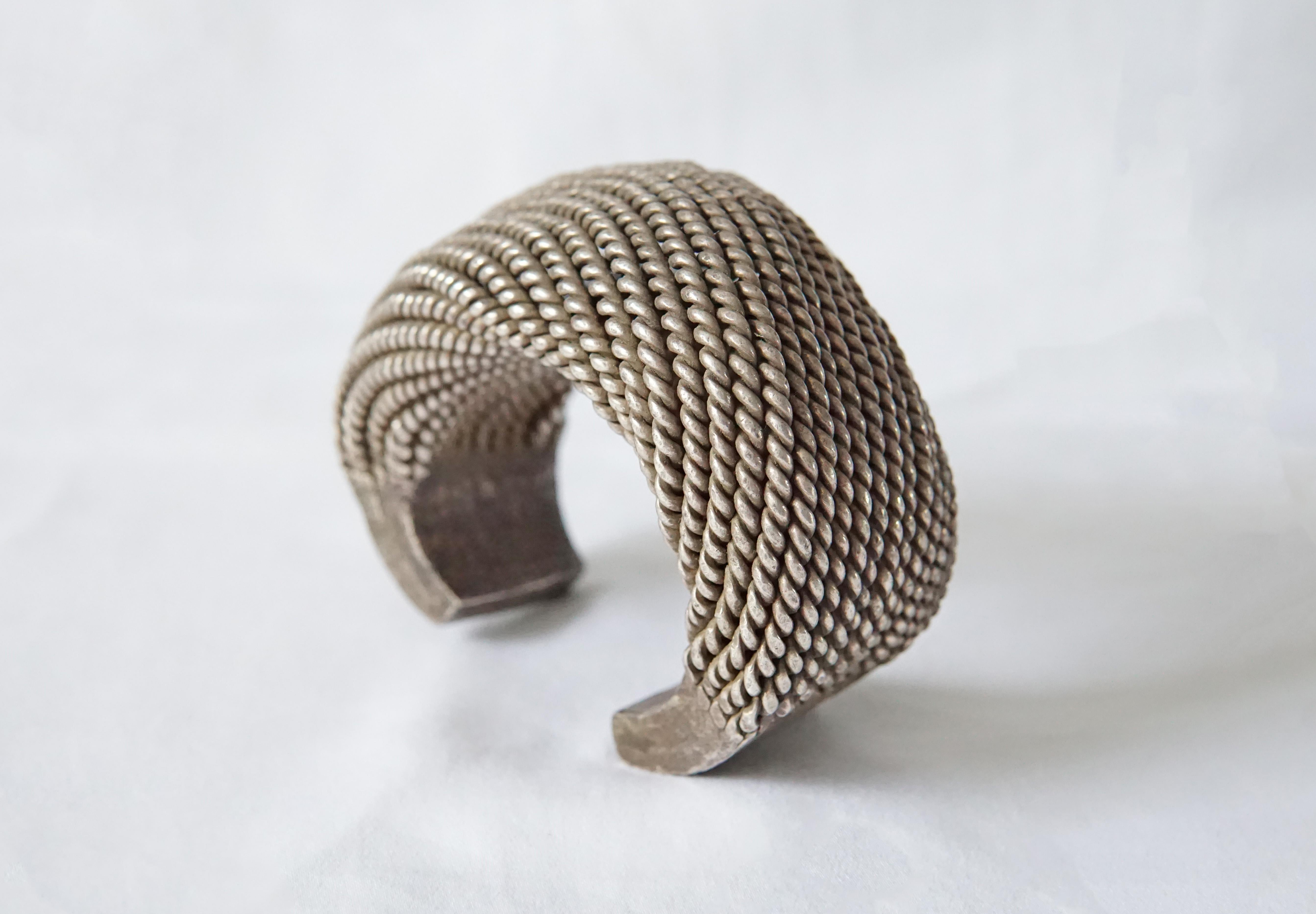 An exceptionally large Akha Tribe woven silver bracelet with spiral design. This Tribal bracelet encompasses tradition Hill tribe silversmithing techniques with each silver strand crafted and woven by hand. This bracelet is slightly adjustable to