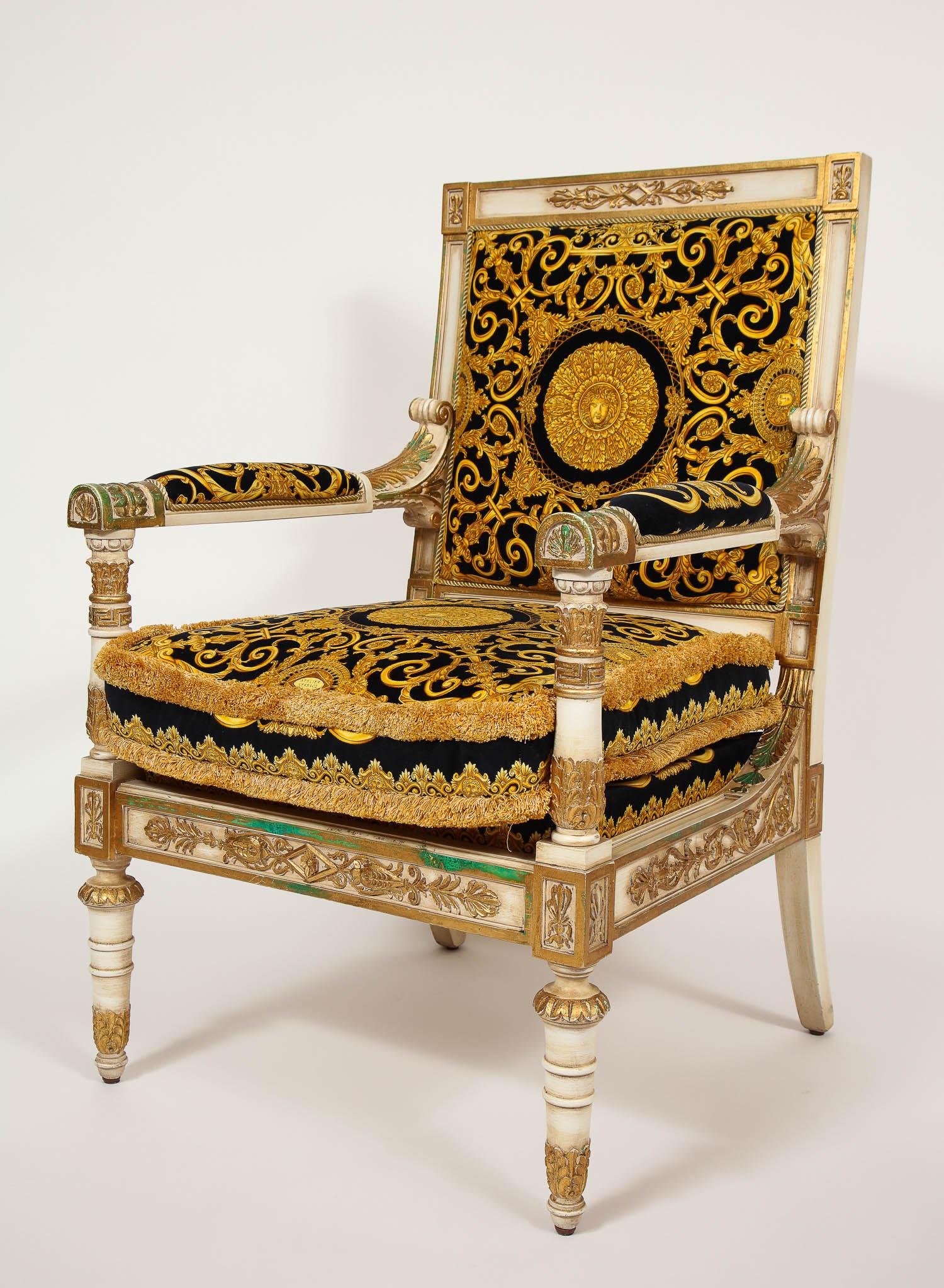 An exceptionally large pair of Empire style Versace armchairs. This magnificent one-of-a-kind Empire Style Versace fauteuils have exceptional craftsmanship; wonderfully hand-carved and detailed giltwood frames, custom upholstered in Versace Empire