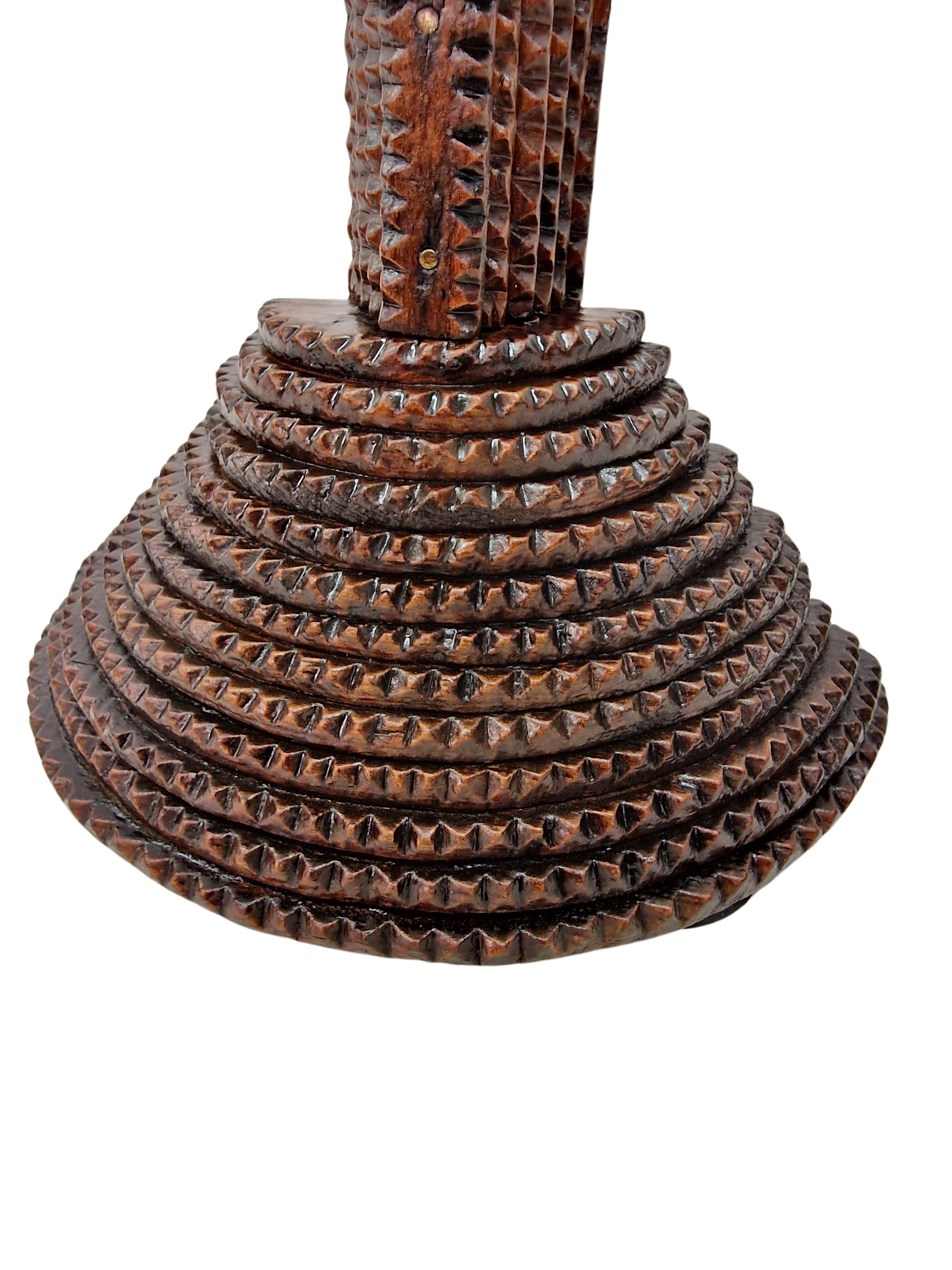 Croix exceptionnellement rare, réalisée dans le style tramp art, en Autriche ou dans le Schwarzwald, en Allemagne, vers 1890 / 1900. 

La croix a une forme typiquement latine et repose sur une base semi-circulaire. La croix et la base sont faites de
