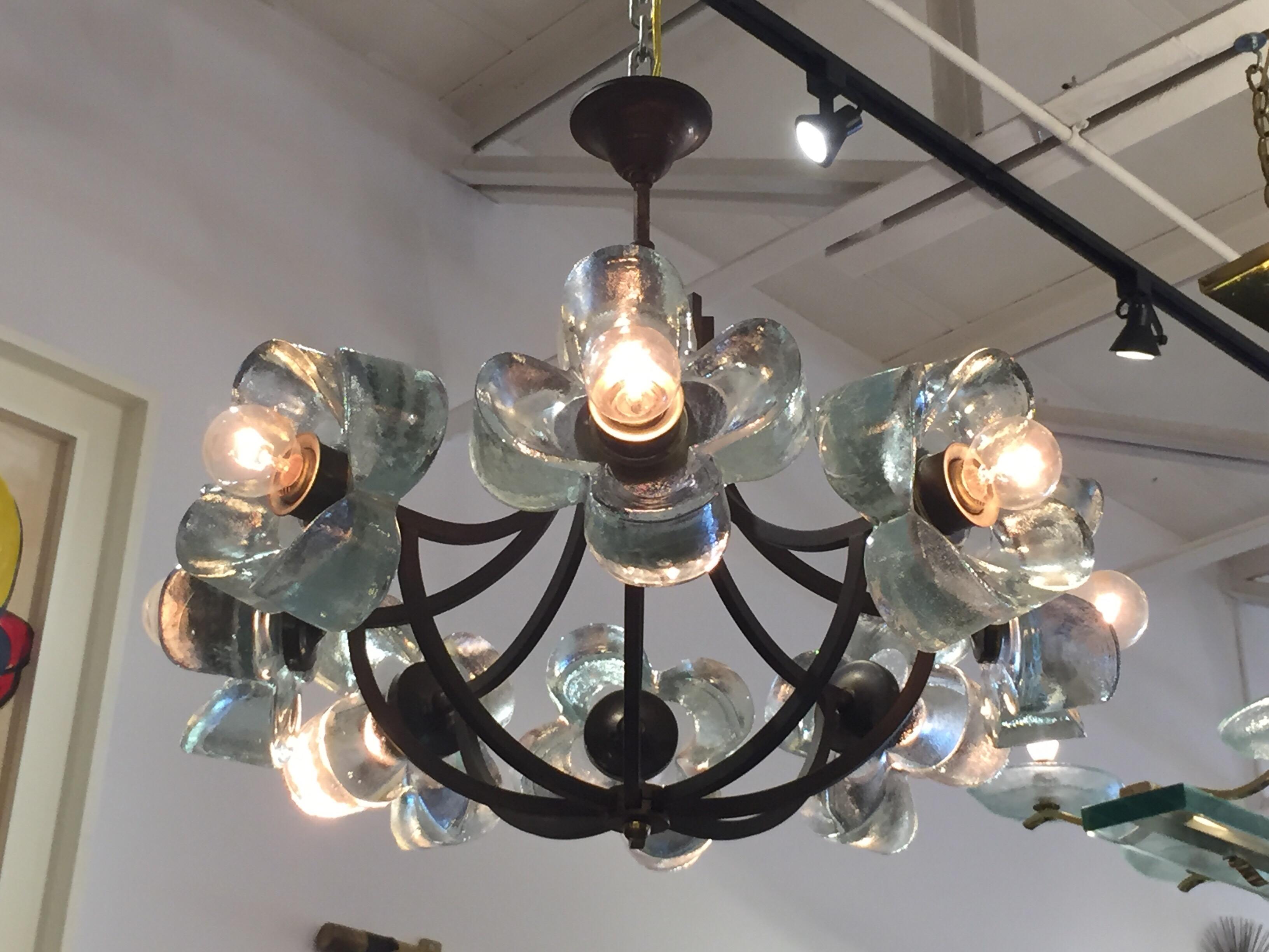 Comprised of 8 molded thick glass daisies, this dark brass framed chandelier is whimsical and unique. All original, as found and working well. E-14 light bulbs (European base and easy to source). The dark brass is patinated by age.