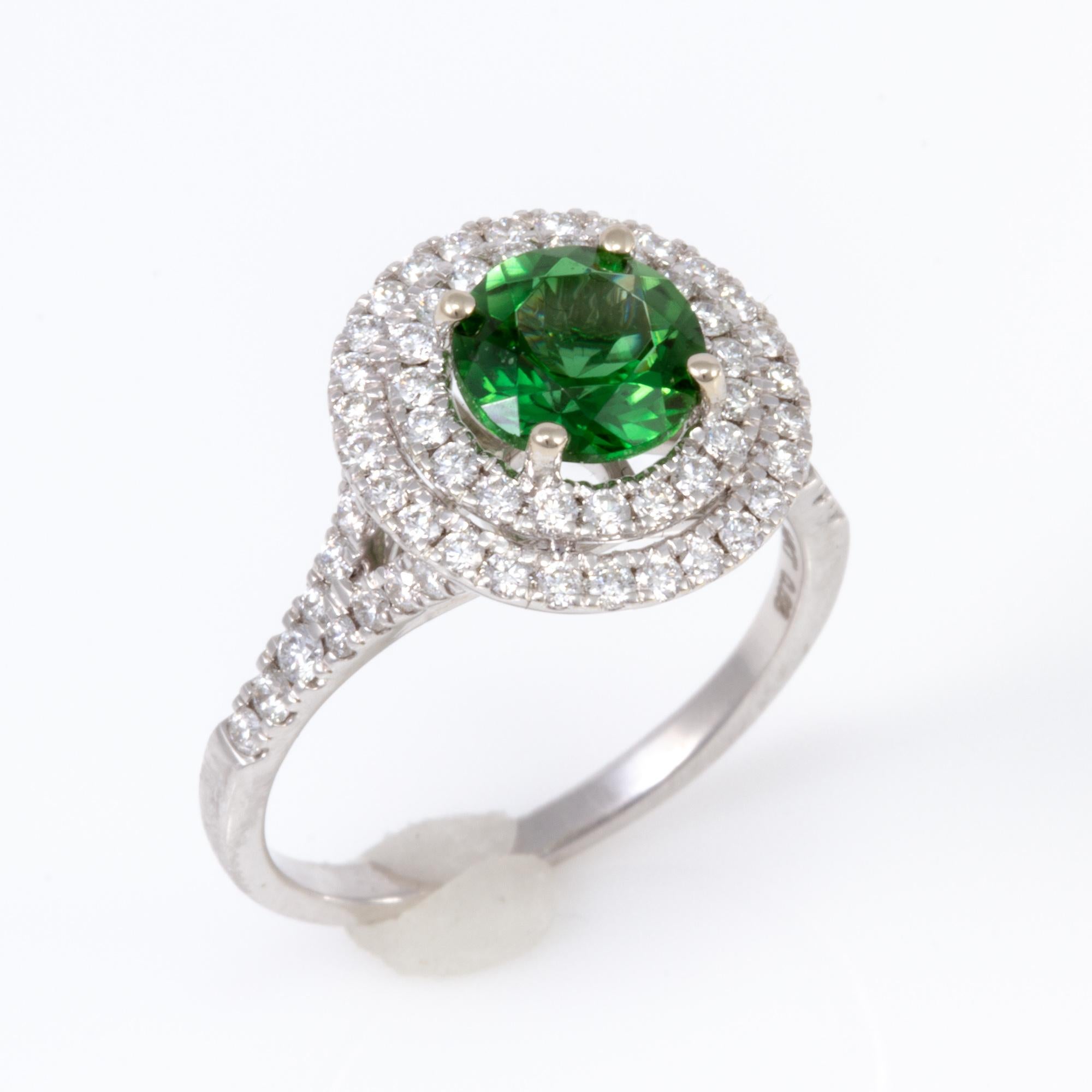 This exceptional Tourmaline is surrounded by a double halo of well cut diamonds weighing  .75 carats.  It is set in 14 karat white gold and was made in America.  Fine Chrome Tourmaline is quite hard to come by, with only Paraiba more rare as far as