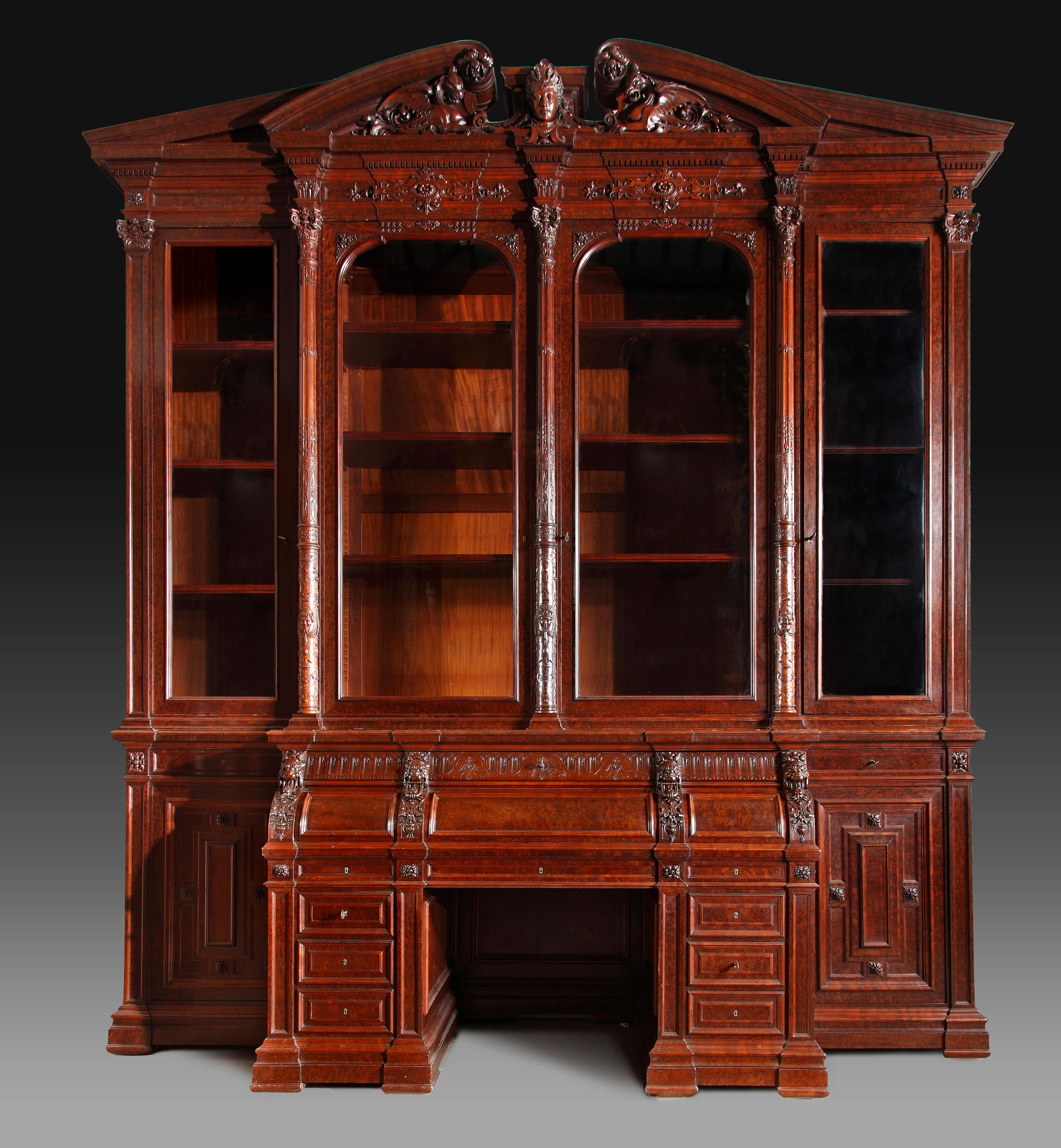 Exceptional neo Renaissance bookcase forming desk. This monumental piece consists in a lower part forming drop-front desk supported by two pillars with drawers. The lateral parts each open with a moulded door. The bookcase occupies the upper part,
