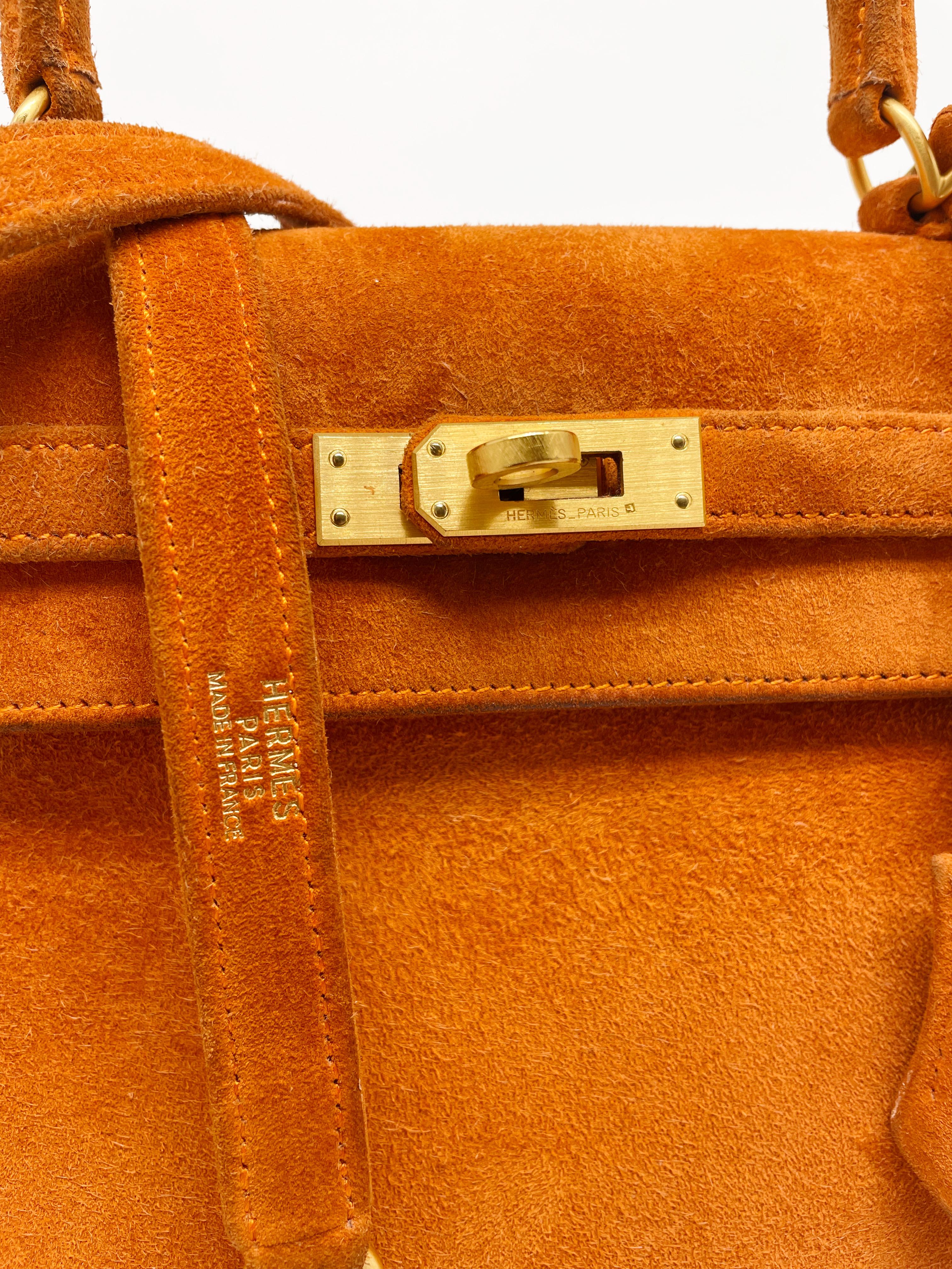 Exceptionnel sac à main Hermès Kelly 25 cm en veau Doblis et quincaillerie raffinée en or brossé, anse simple en daim orange, anse simple amovible en cuir daim orange permettant de le porter à la main ou à l'épaule.

Fermeture à rabat.
Doublure