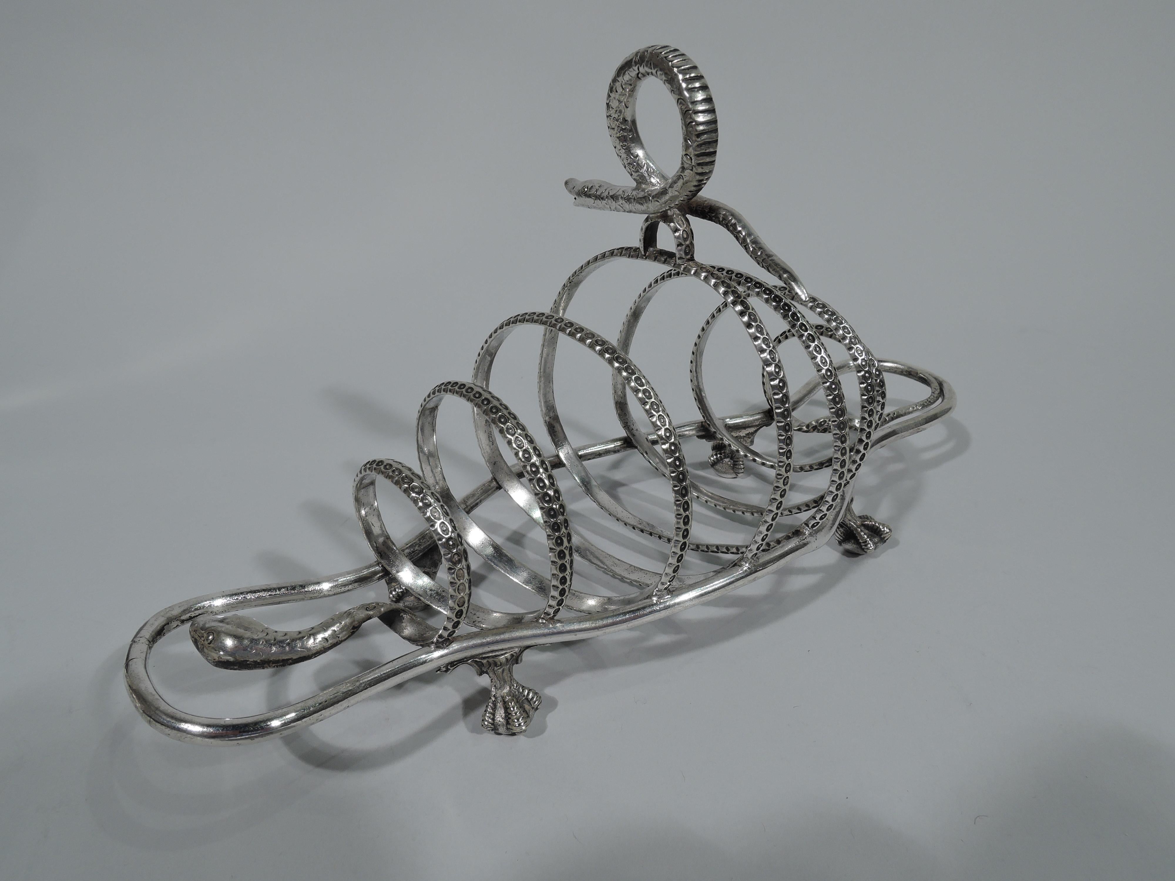 Exciting and unusual silver plate toast rack, circa 1890. Seven partitions in form of scaly, spiralling snake. Ring finial in form of second smaller snake. Open shaped frame with four claw-and-ball feet. Marked “DB”.