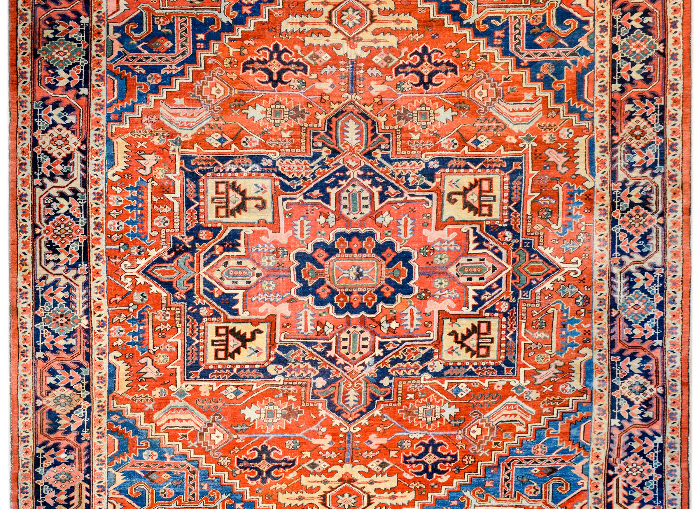 An exciting, beautiful rendered, early 20th century Persian Heriz rug with an elaborately woven multicolored stylized floral and leaf pattern woven in crimson, indigo, gold, green, and salmon colored wool. The border is wonderful with a wide central