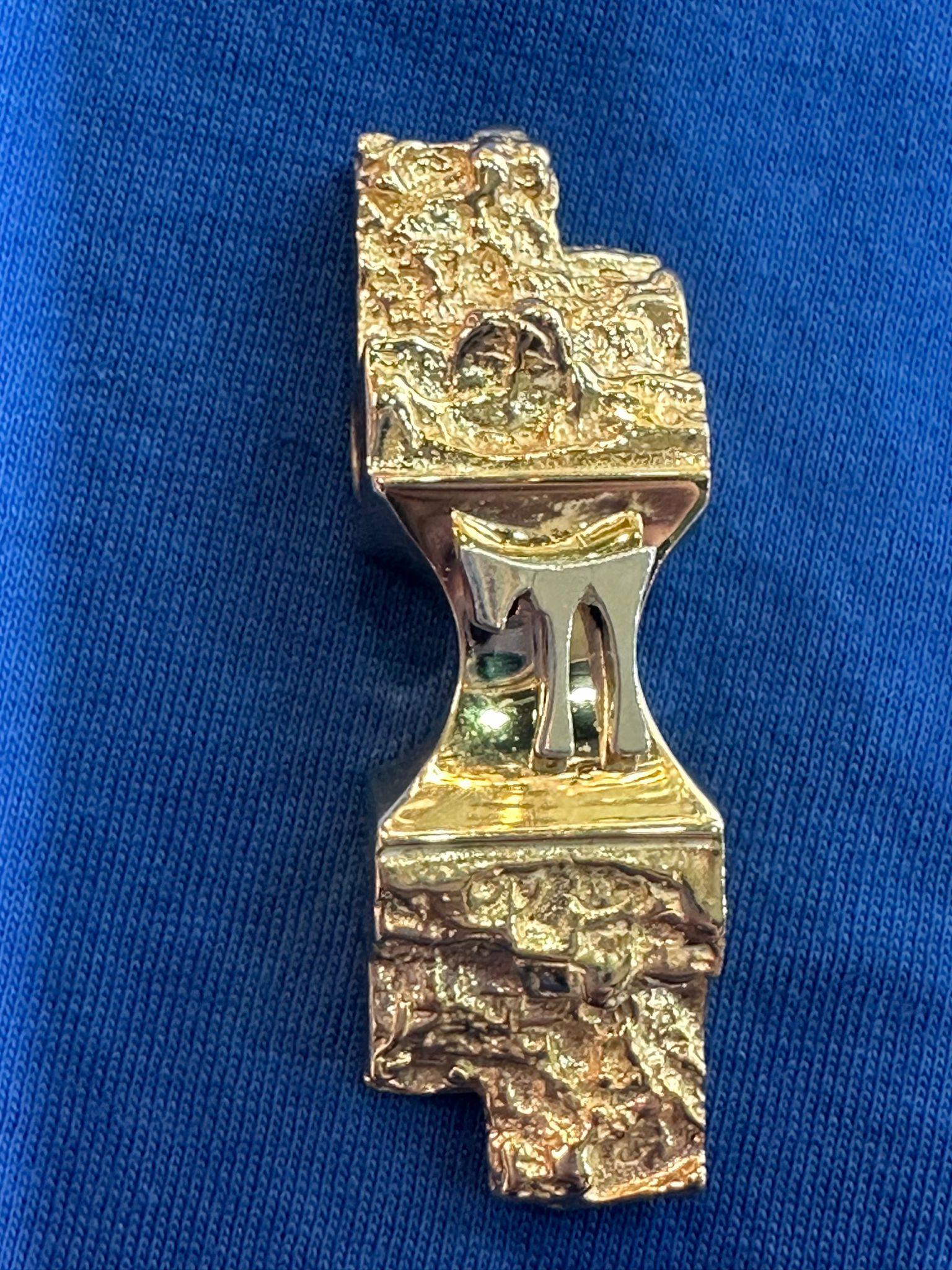 This stunning and substantial 21.5-gram pendant is crafted from 14K gold, designed in the form of Jerusalem stone, reflecting the historical and spiritual significance of the Holy City. The pendant’s textured gold surface emulates the rugged beauty